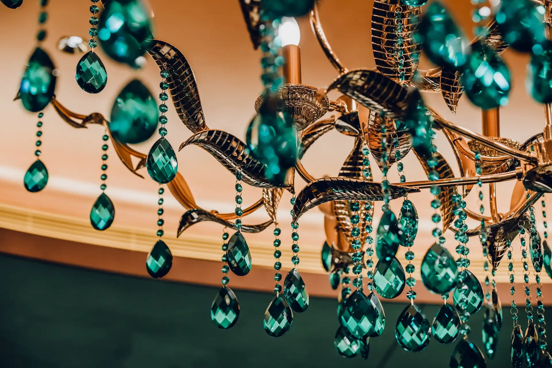 Grand Imperial Court emerald crystal chandelier detail at MGM Macao featuring faceted green glass drops beaded crystal strands and sculptural metal framework suspended beneath illuminated ceiling recess within a luxury Chinese restaurant interior design