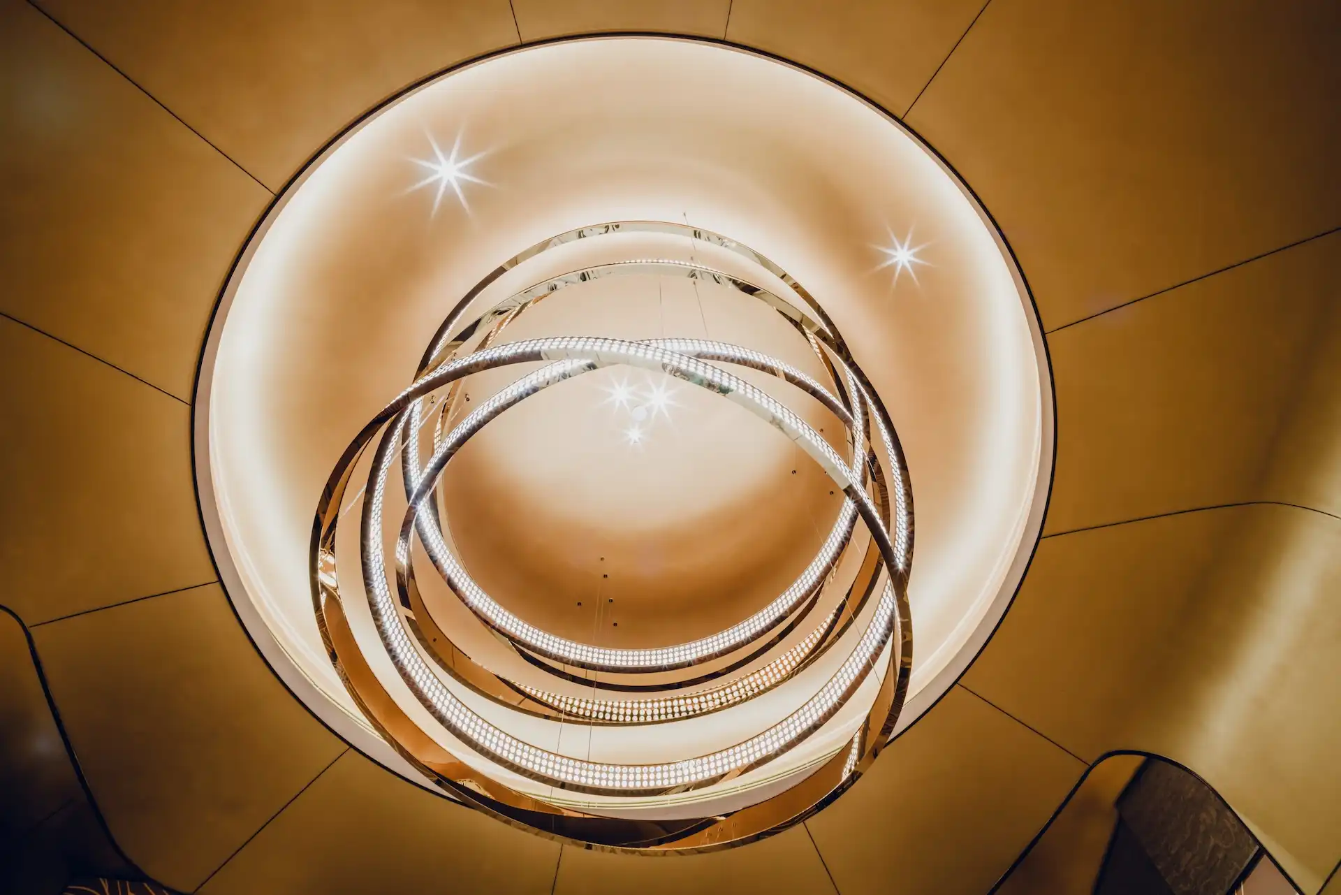 Grand Imperial Court sculptural circular chandelier detail at MGM Macao featuring interlocking illuminated metal rings suspended within a recessed ceiling dome, highlighting bespoke lighting design and refined ceiling architecture in a luxury Chinese restaurant interior