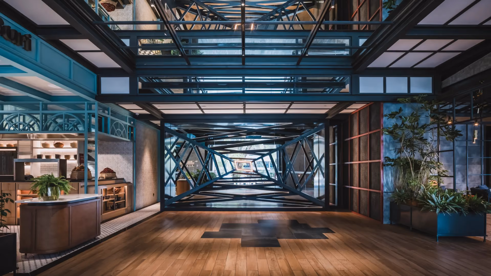 Arrival lobby at Hyatt Centric City Centre Kuala Lumpur, with teal steel framing, timber flooring and the tin mining dredger sculptural wall