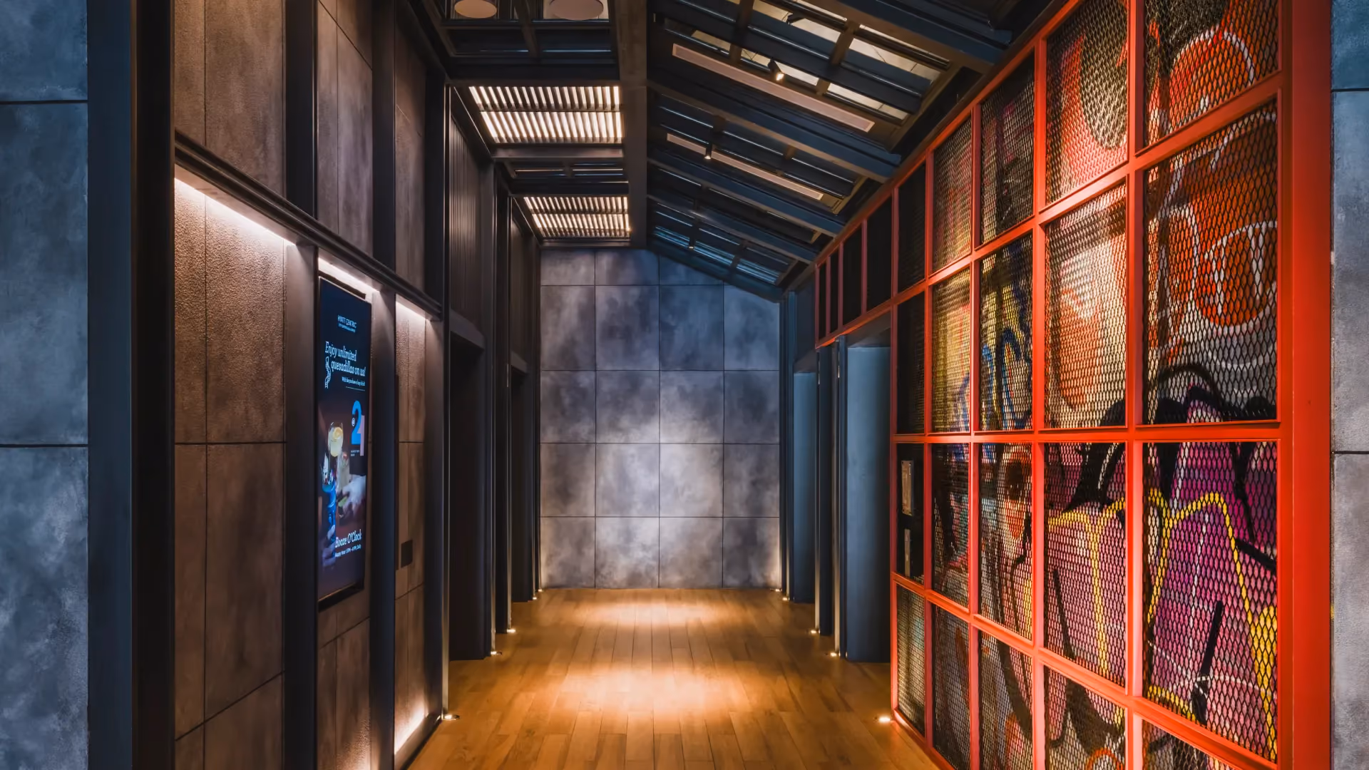 Ground floor lift lobby at Hyatt Centric City Centre Kuala Lumpur, with graffiti art behind a red steel grid and timber flooring