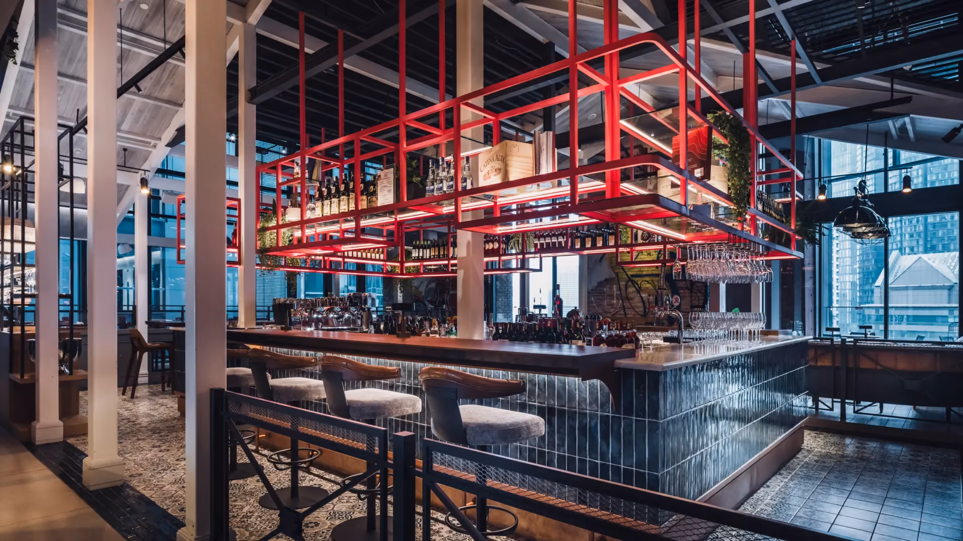 The Foundry main bar at IL Forno, Hyatt Centric City Centre Kuala Lumpur, with a pink steel gantry above a deep counter and city views