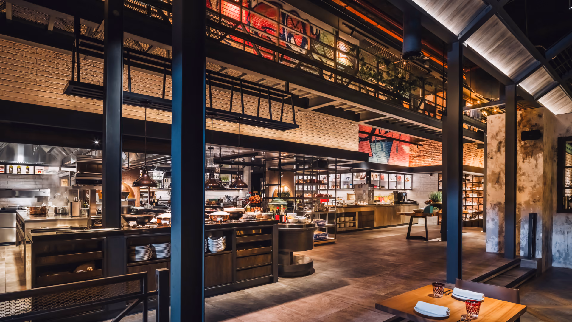 The Range show kitchen at IL Forno, Hyatt Centric City Centre Kuala Lumpur, with a staff catwalk above, brick walls and steel columns
