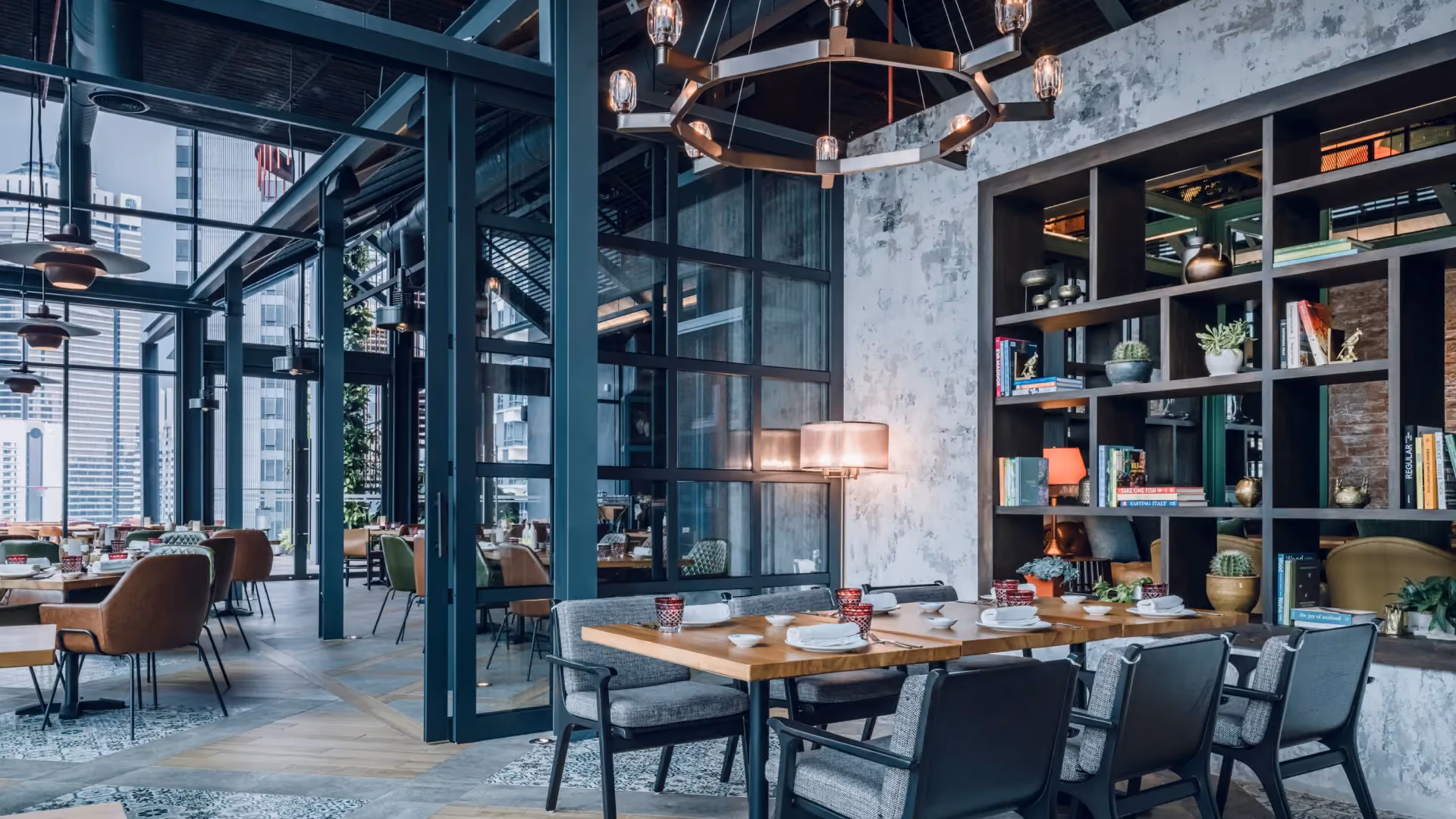 The Gallery at IL Forno, Hyatt Centric City Centre Kuala Lumpur, with steel-framed glazing, bookshelves, a copper chandelier and dining tables