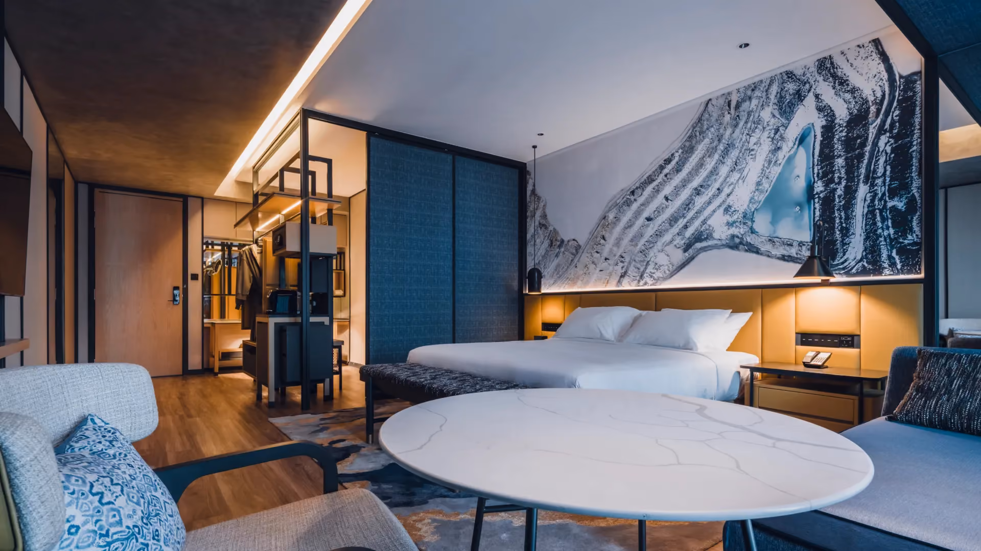 Standard King guestroom at Hyatt Centric City Centre Kuala Lumpur, with an open cast tin mine mural, denim blue wall and a round marble table