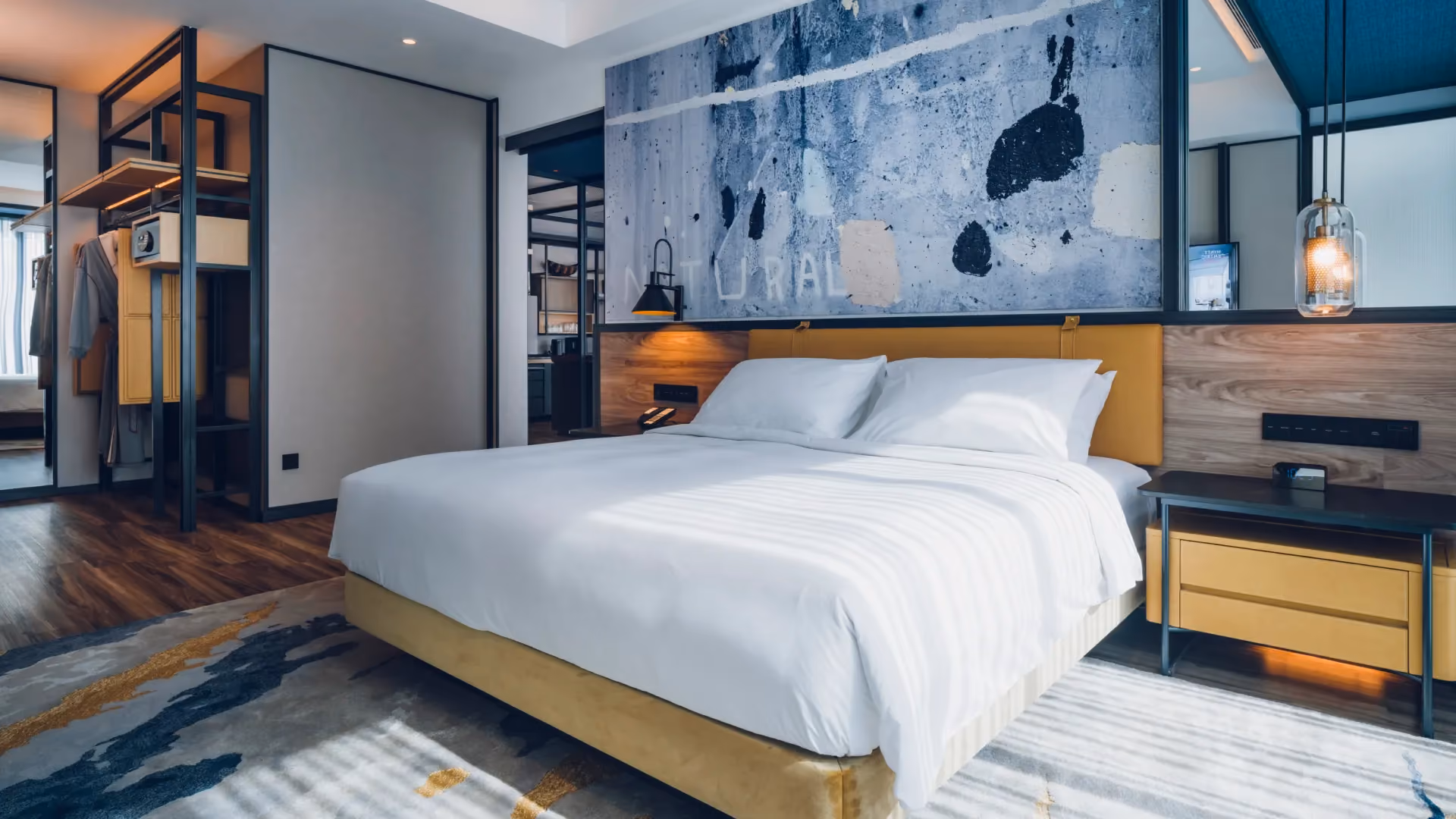 Hospitality Suite bedroom at Hyatt Centric City Centre Kuala Lumpur, with large-scale artwork, a leather headboard and an open steel-framed wardrobe