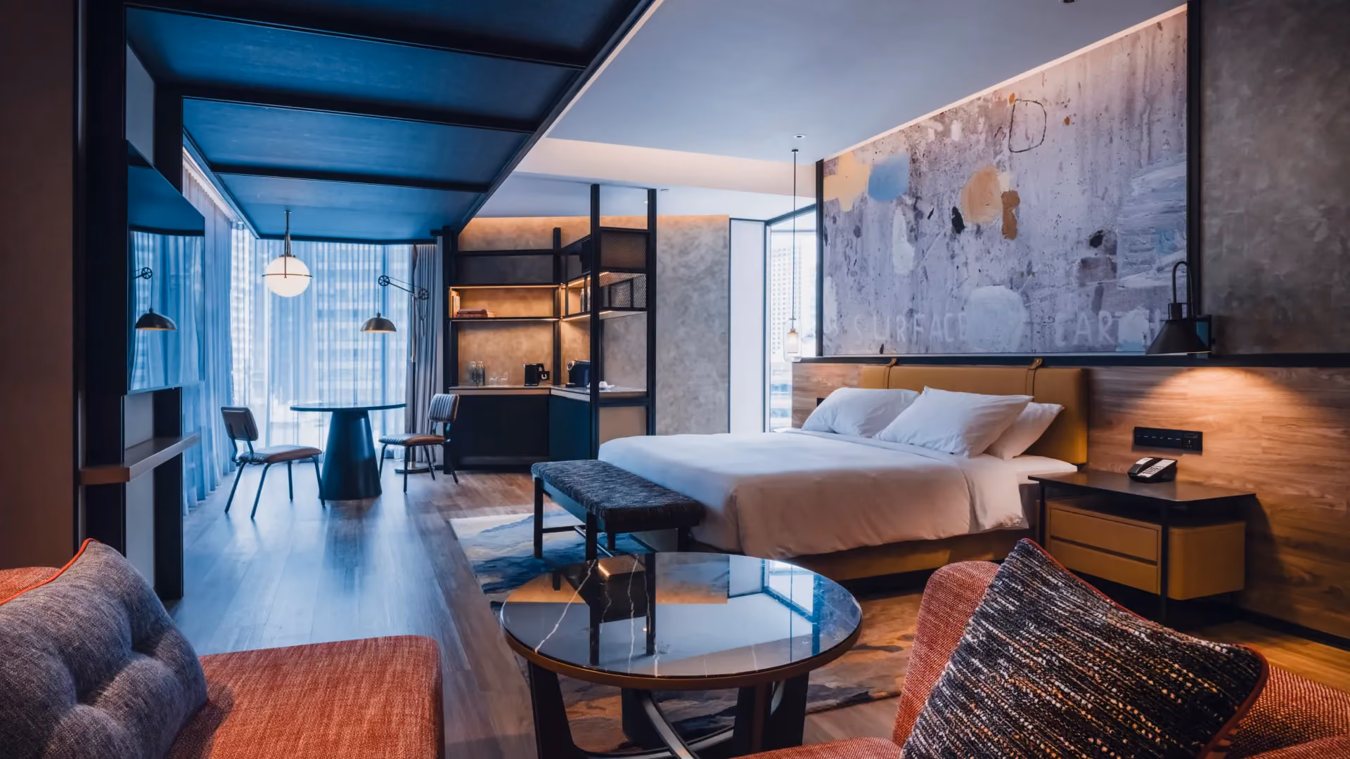 Studio Suite at Hyatt Centric City Centre Kuala Lumpur, with denim blue walls, a leather headboard, red armchairs and a window dining table