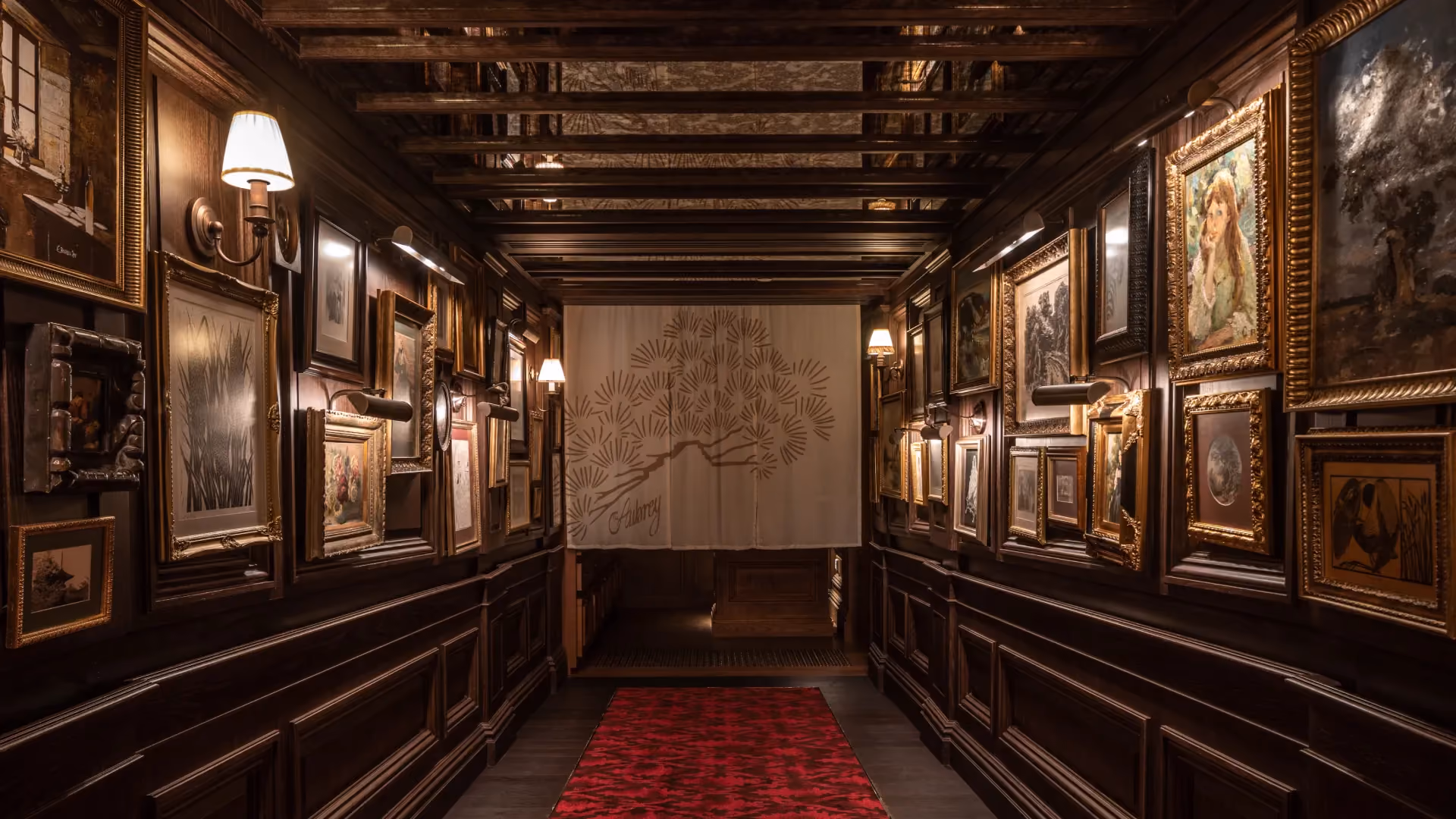 Entrance passage at The Aubrey, Mandarin Oriental Hong Kong, with framed artworks on timber panelling and a painted screen at the end of the corridor