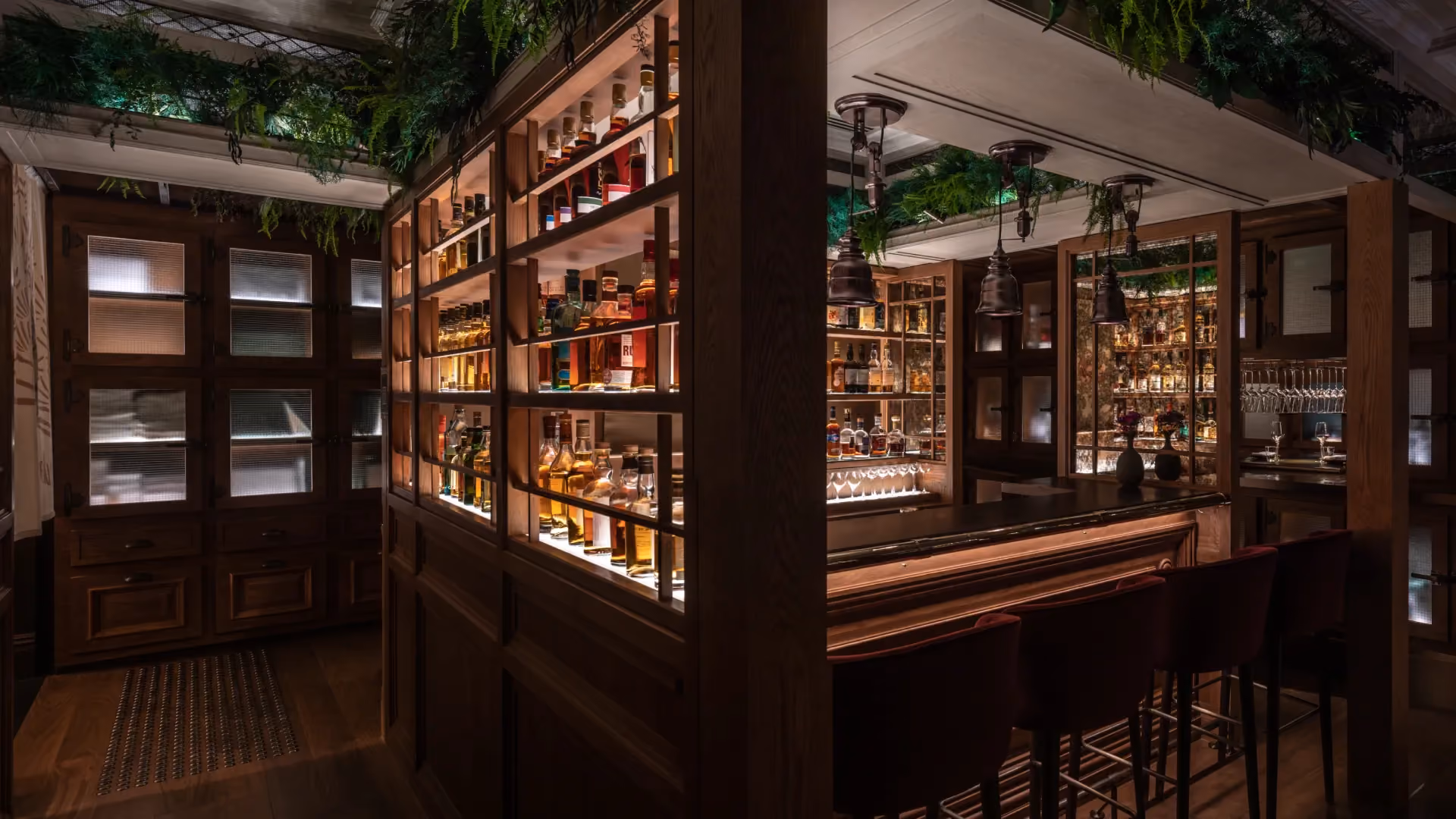 Whisky bar at The Aubrey, Mandarin Oriental Hong Kong, with illuminated whisky display cabinets and a dark timber bar counter