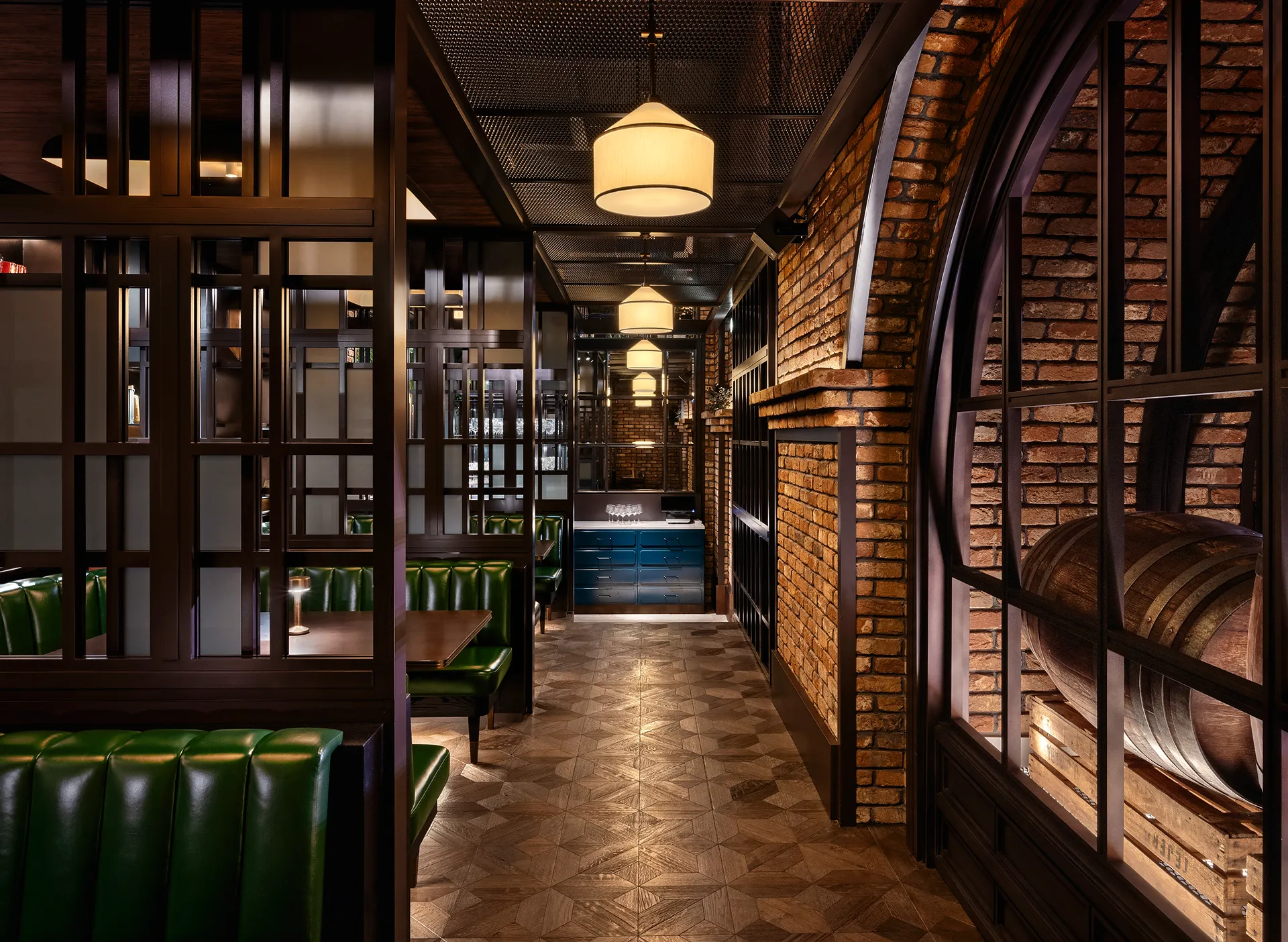 Booth corridor at Broadway, Emirates Palace Abu Dhabi, with green leather banquettes, steel-framed screens and brick arches revealing beer barrels