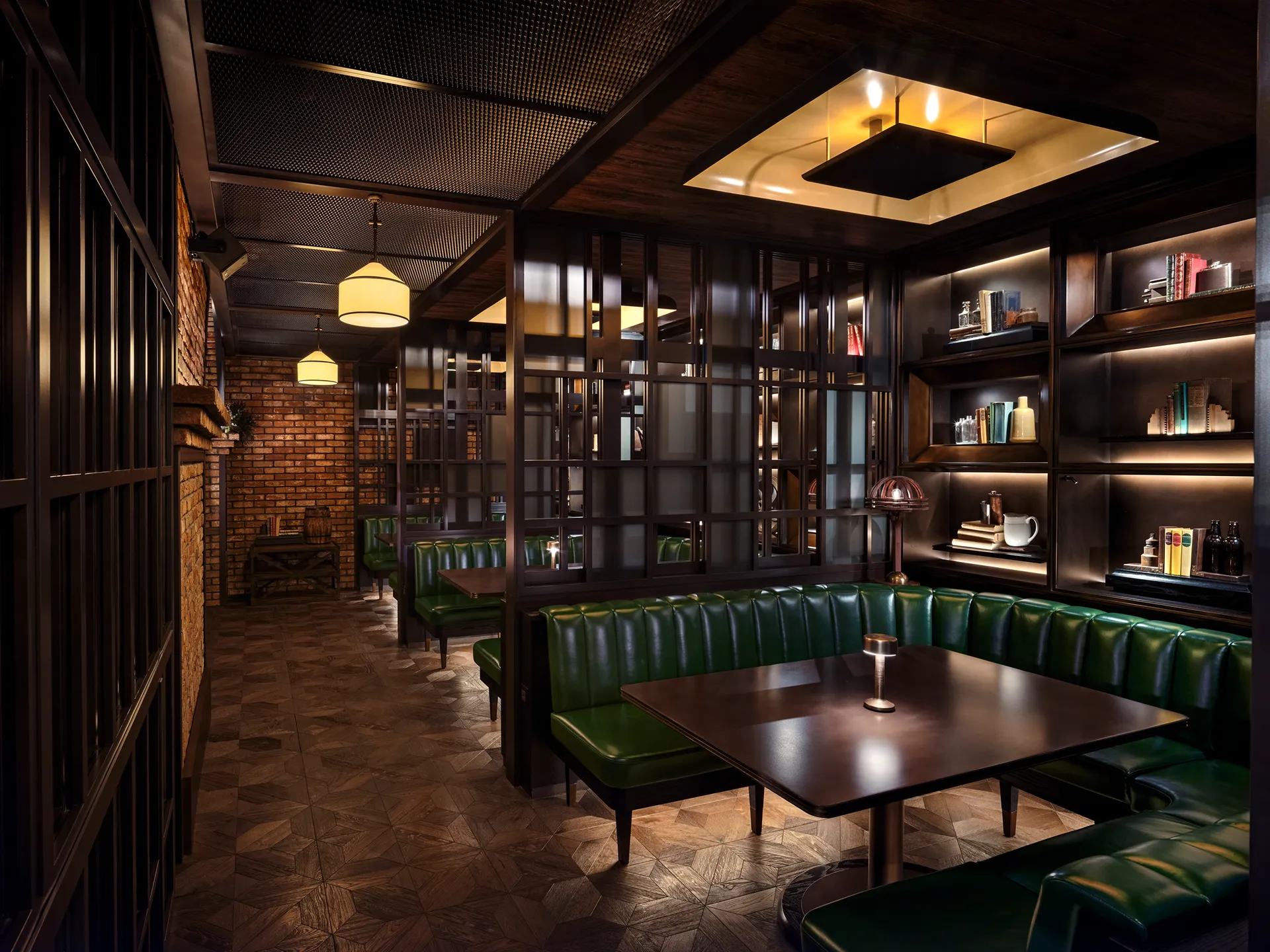 Private booth at Broadway, Emirates Palace Abu Dhabi, with green leather banquette seating, a lit display shelf wall and steel-framed screens