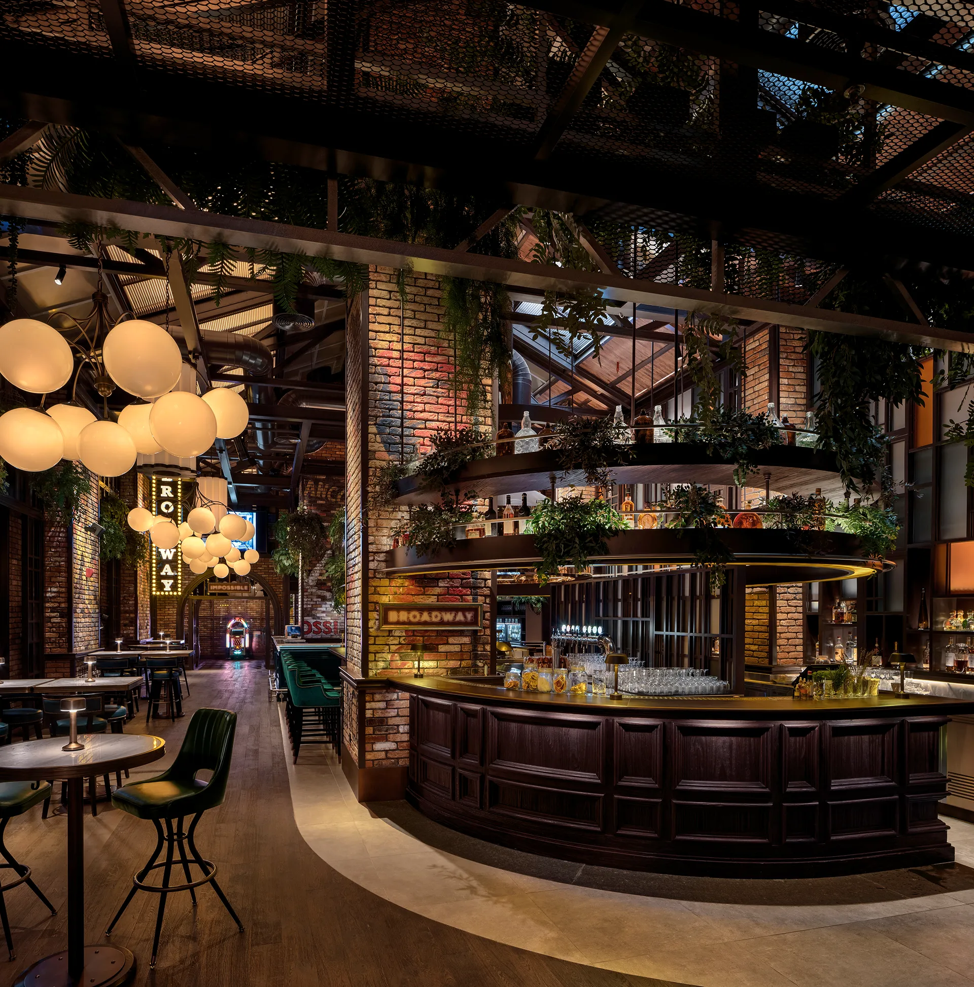 Main bar at Broadway, Emirates Palace Abu Dhabi, with a dark timber bar front, tiered bottle display above and globe pendant clusters