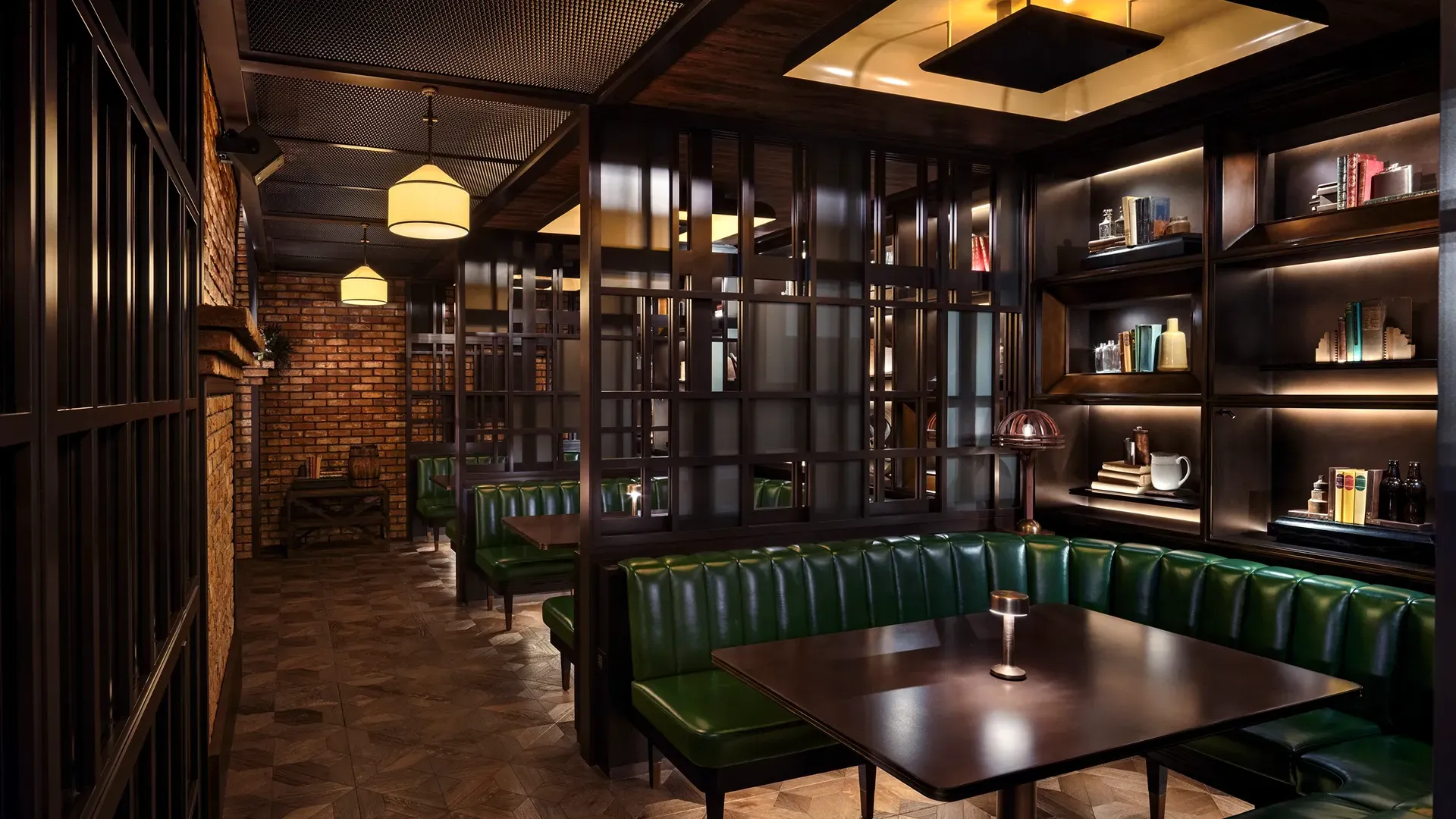 Private booth at Broadway, Emirates Palace Abu Dhabi, with green leather banquette seating, a lit display shelf wall and steel-framed screens