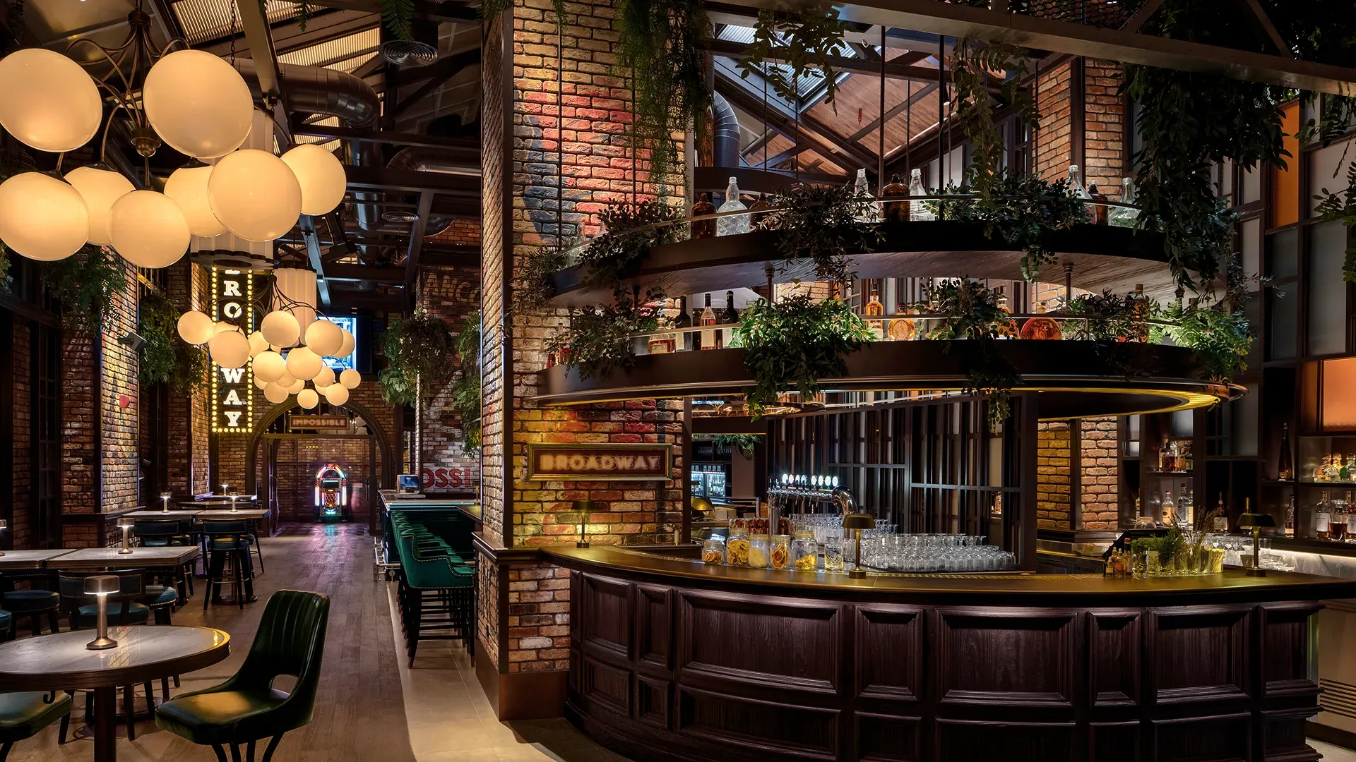 Main bar at Broadway, Emirates Palace Abu Dhabi, with a dark oak bar, tiered display shelving with greenery, globe pendant clusters and neon Broadway signage