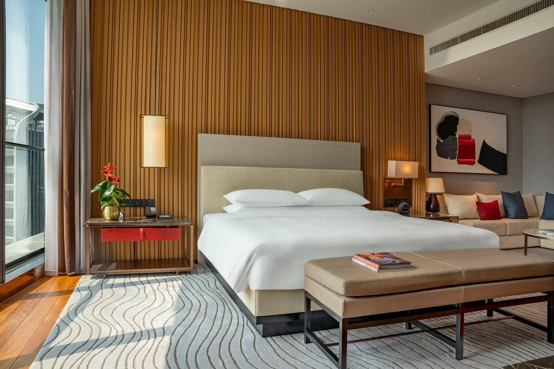 Presidential suite bedroom at Hyatt Regency Hengqin with timber headwall and red accent cushions