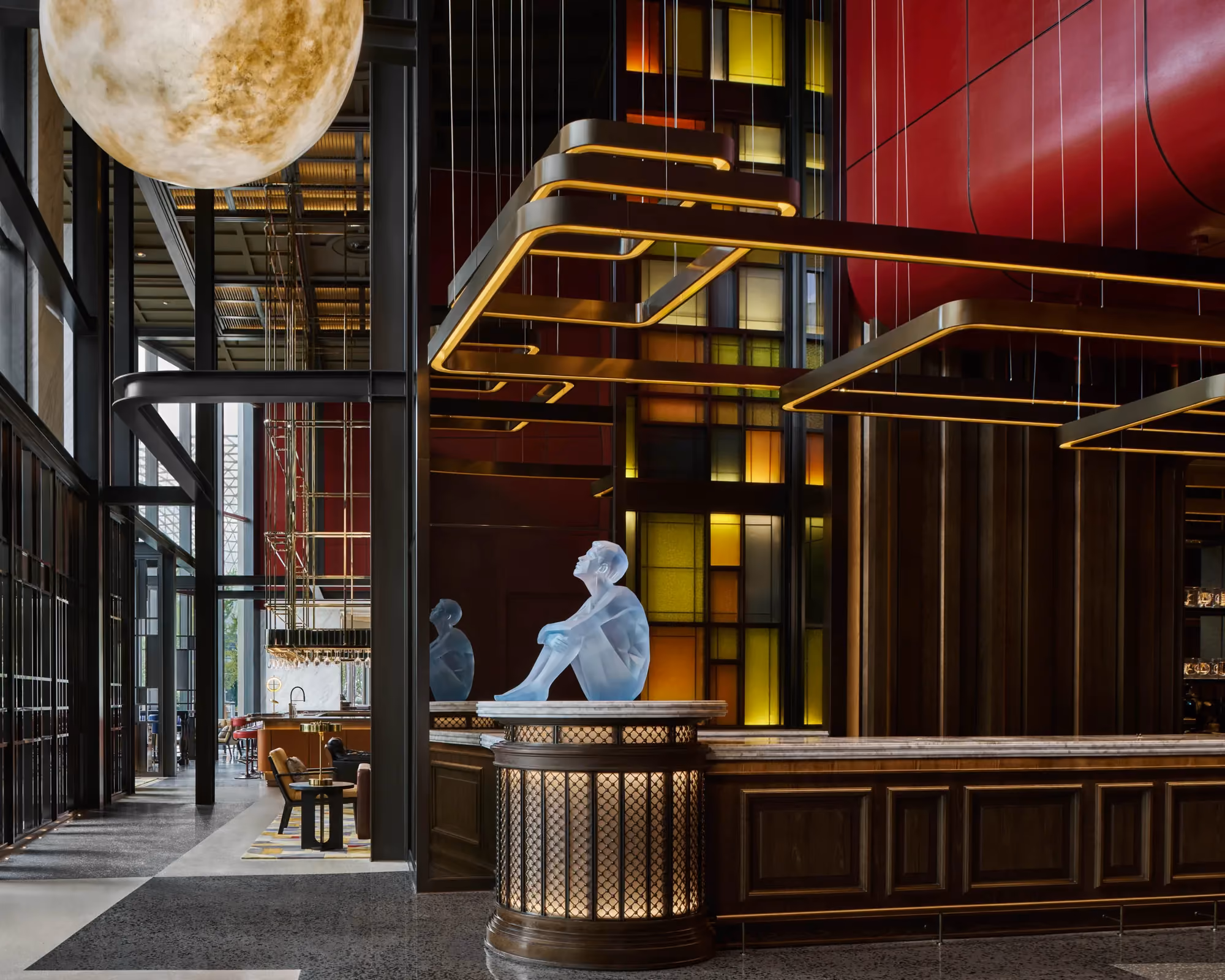 Lobby reception at Thompson Shanghai Expo with a blue seated sculpture and fluted brass desk