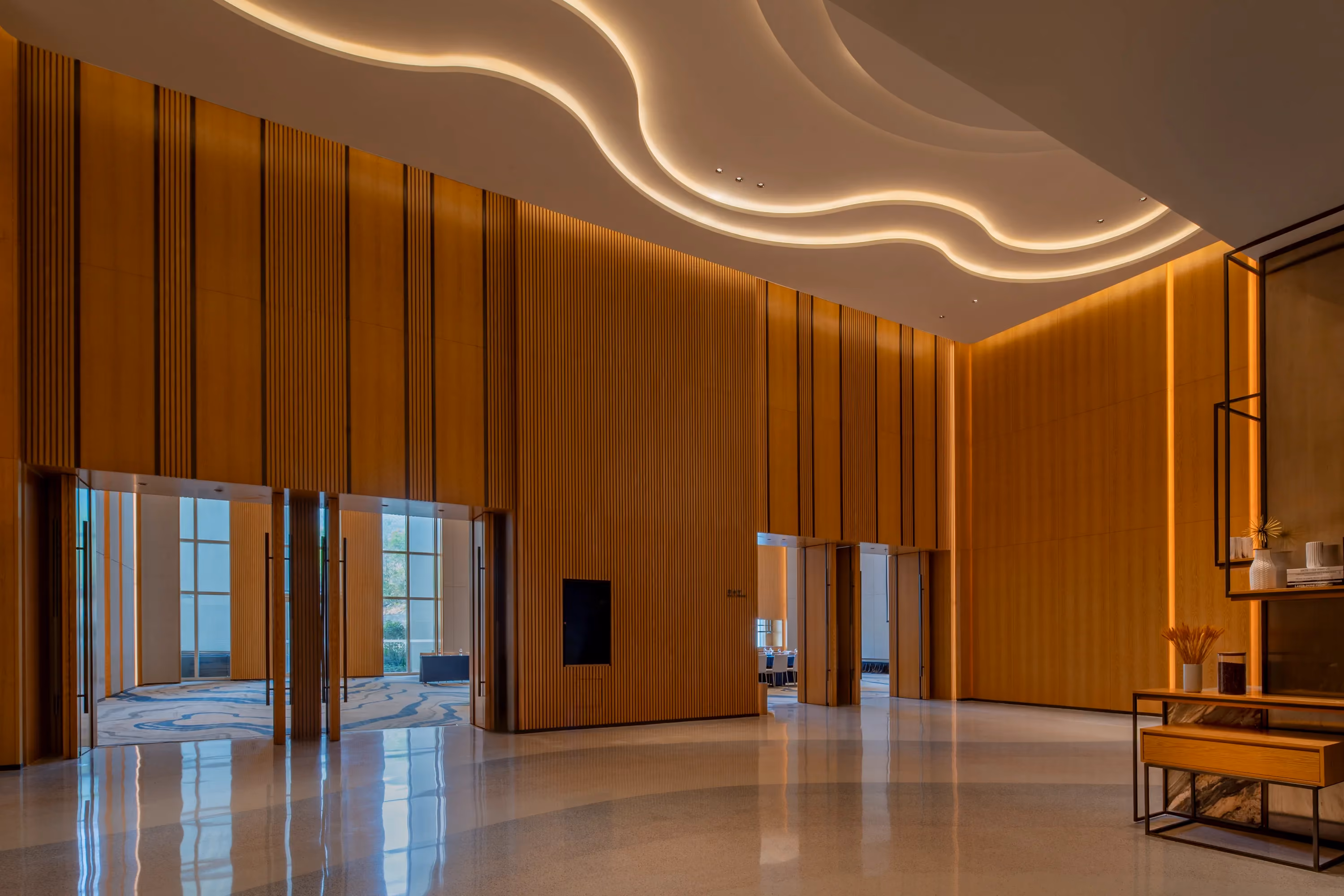 Ballroom foyer at Hyatt Regency Ocean Paradise Resort, with vertical timber slats and a curved cove-lit ceiling