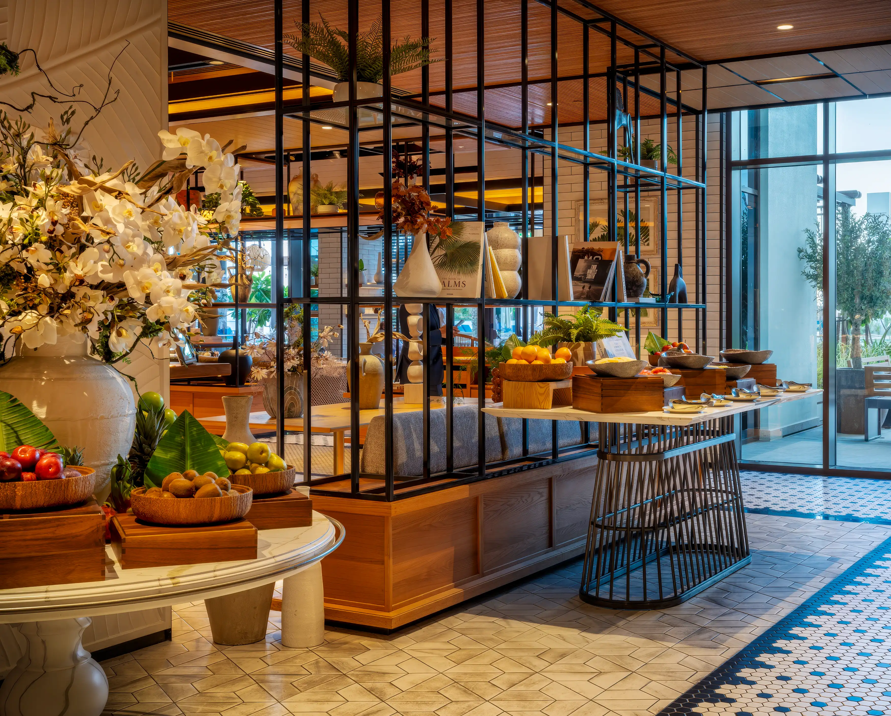 Fresh fruit buffet displays on timber plinths framed by black steel shelving at Rawya, Mandarin Oriental, Muscat