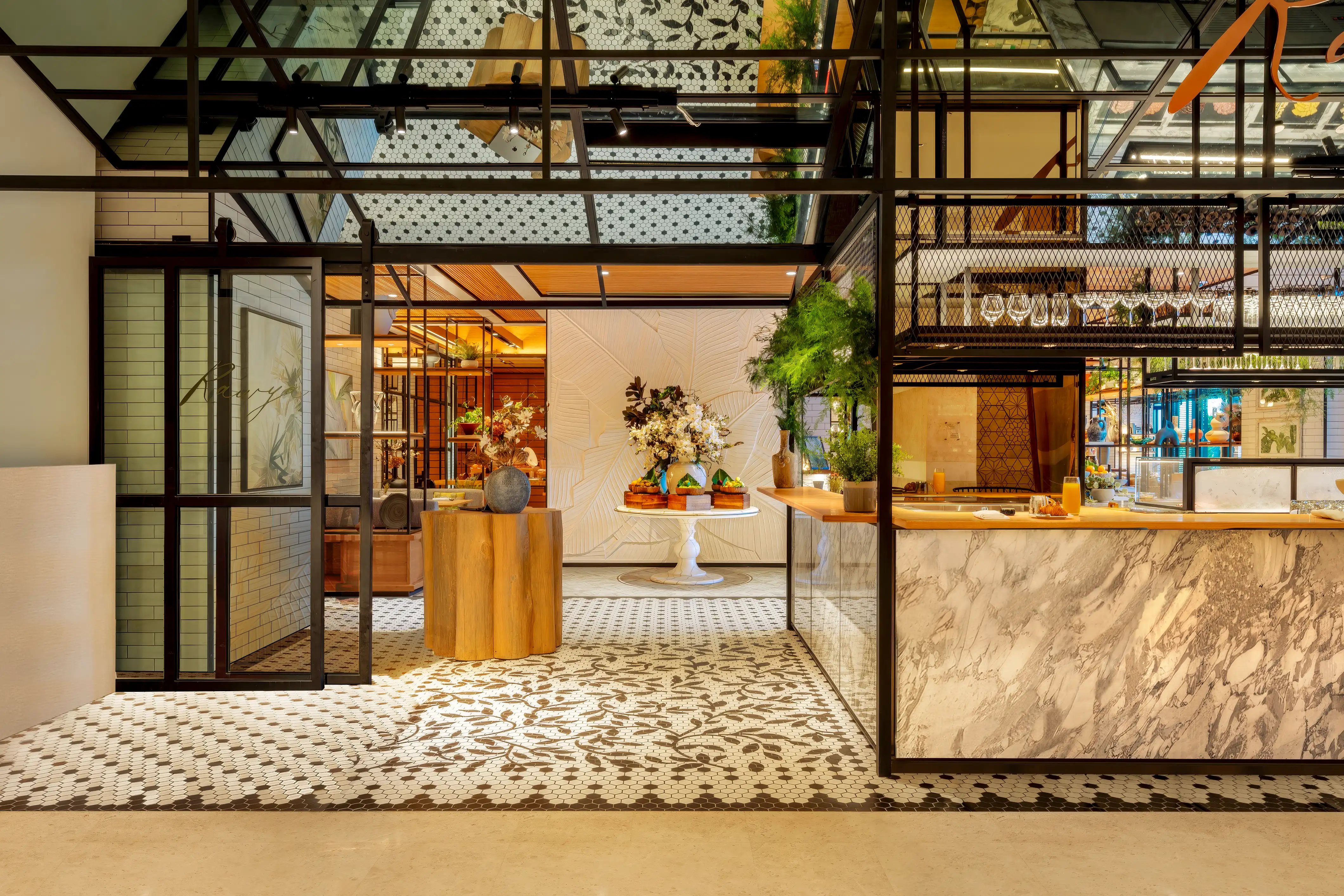 Black and white hexagonal mosaic floor and marble-clad counter beneath a perforated black steel canopy at Rawya, Mandarin Oriental, Muscat