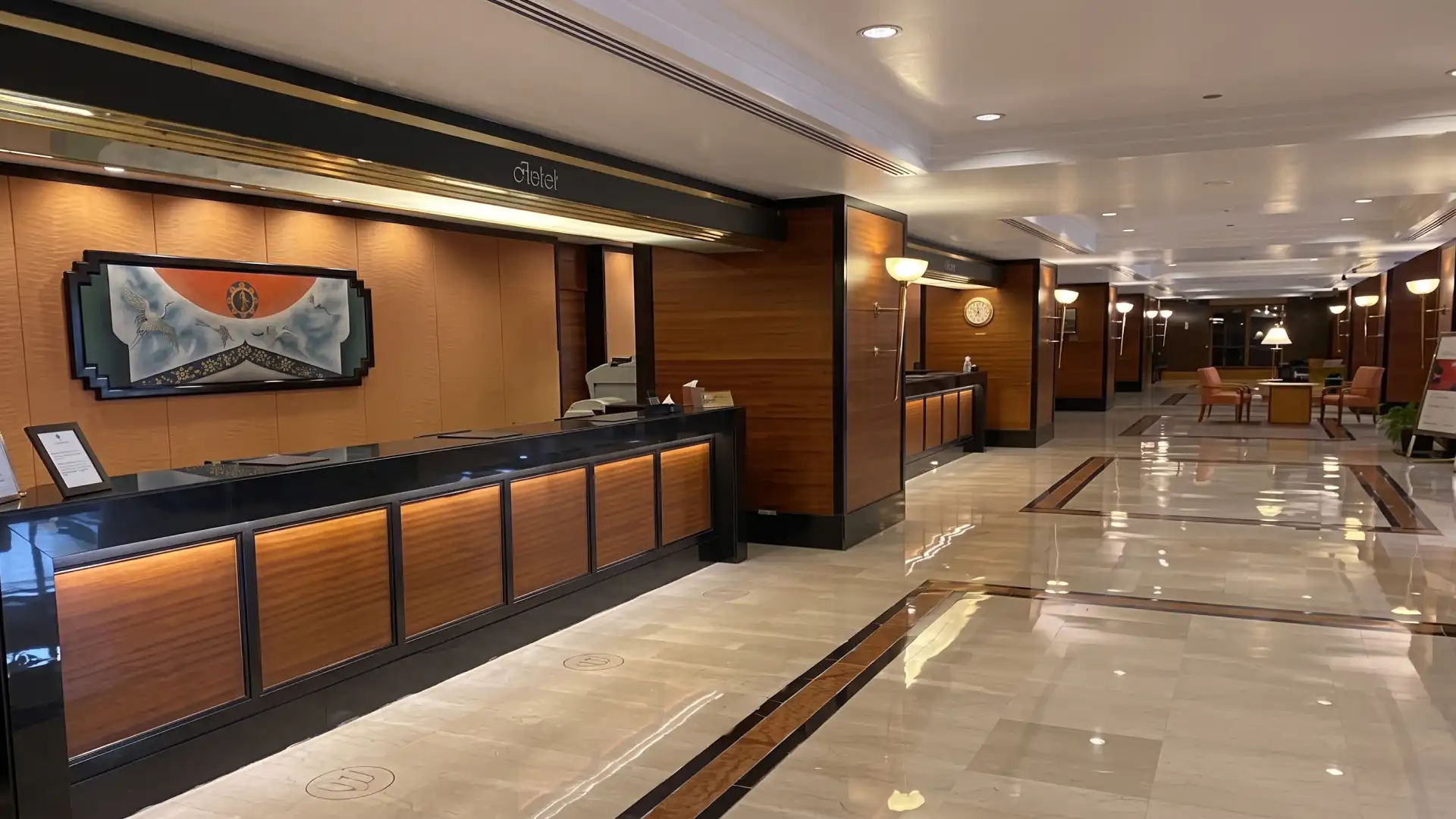 Before refurbishment: arrival reception with a dark timber-fronted desk and coffered, downlit ceiling at Trident, Nariman Point