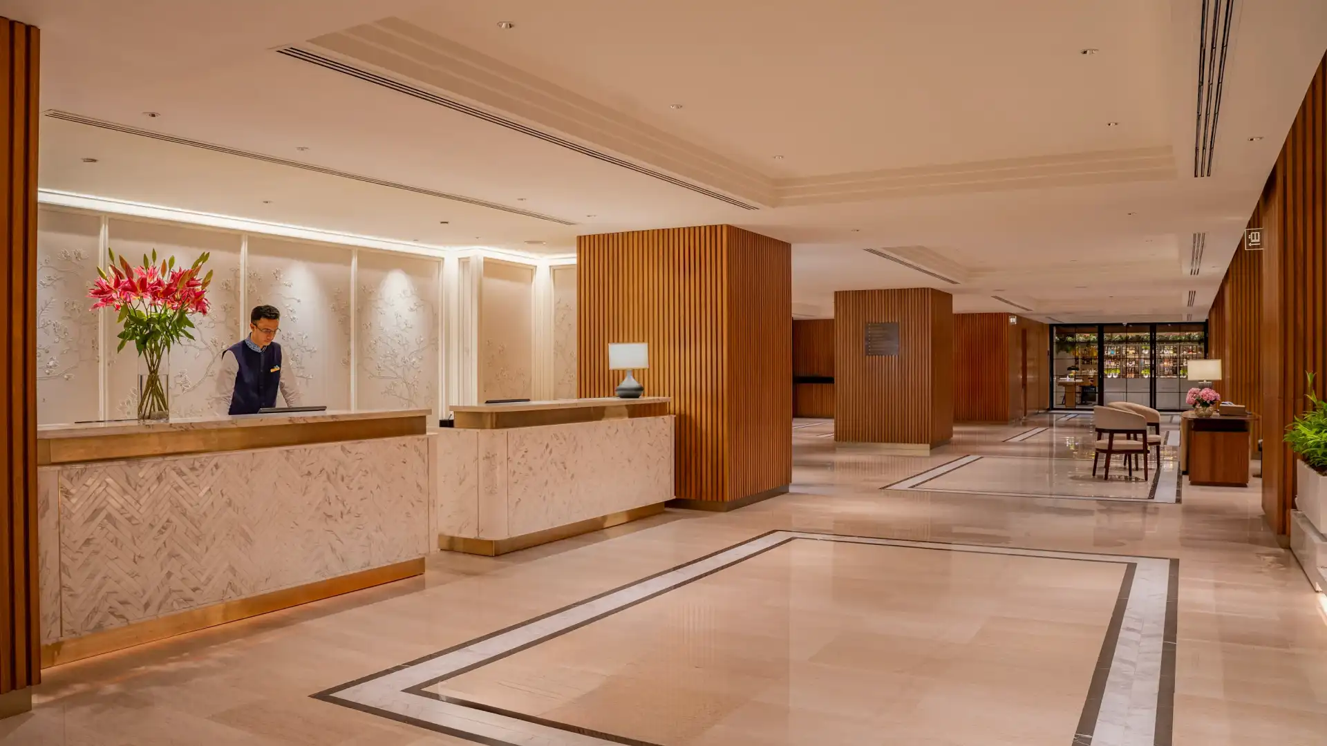After refurbishment: arrival reception with refinished desks, a backlit feature wall and fluted timber columns at Trident, Nariman Point