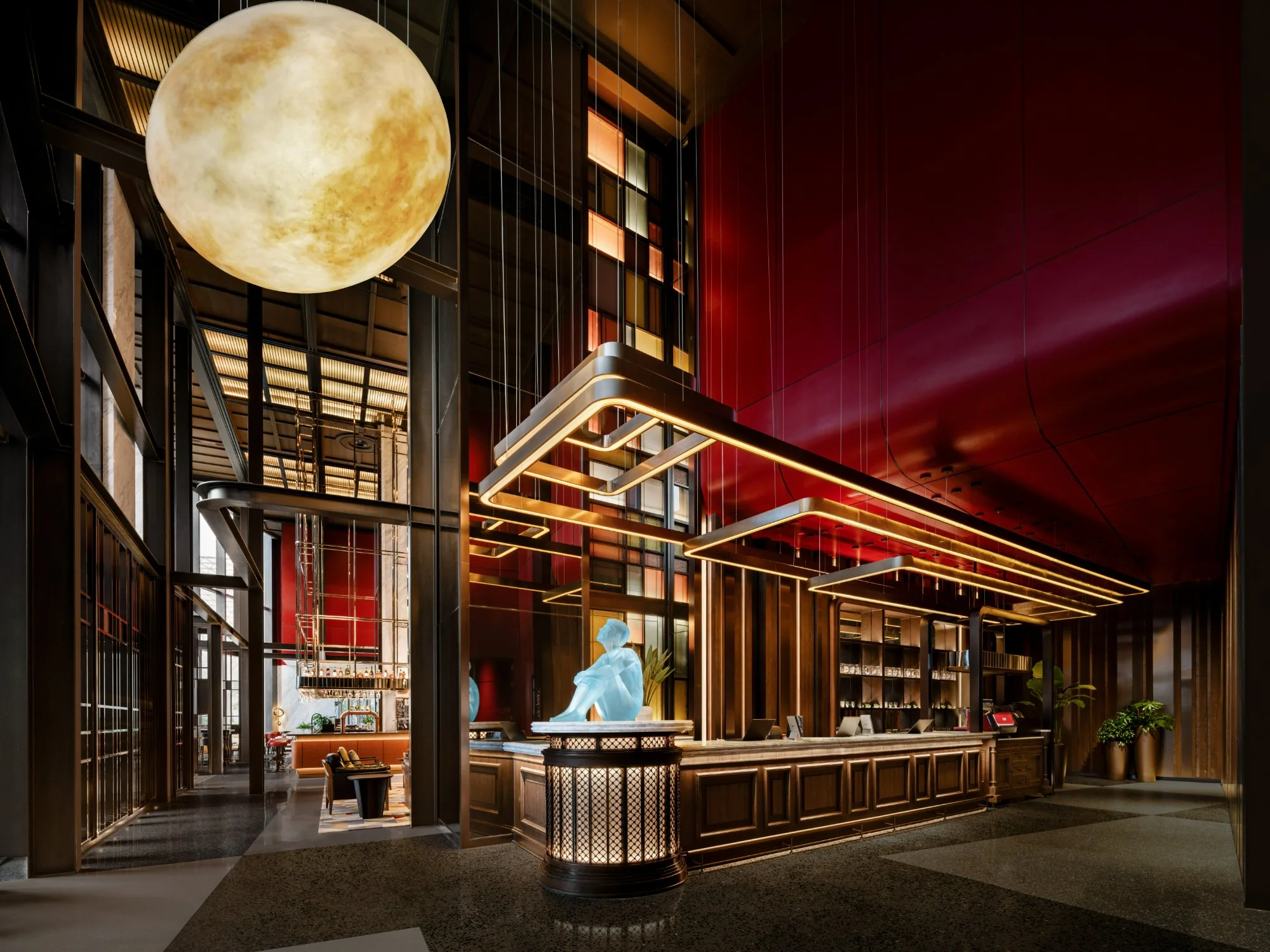 Lobby reception at Thompson Shanghai Expo with a fluted brass desk and blue seated sculpture