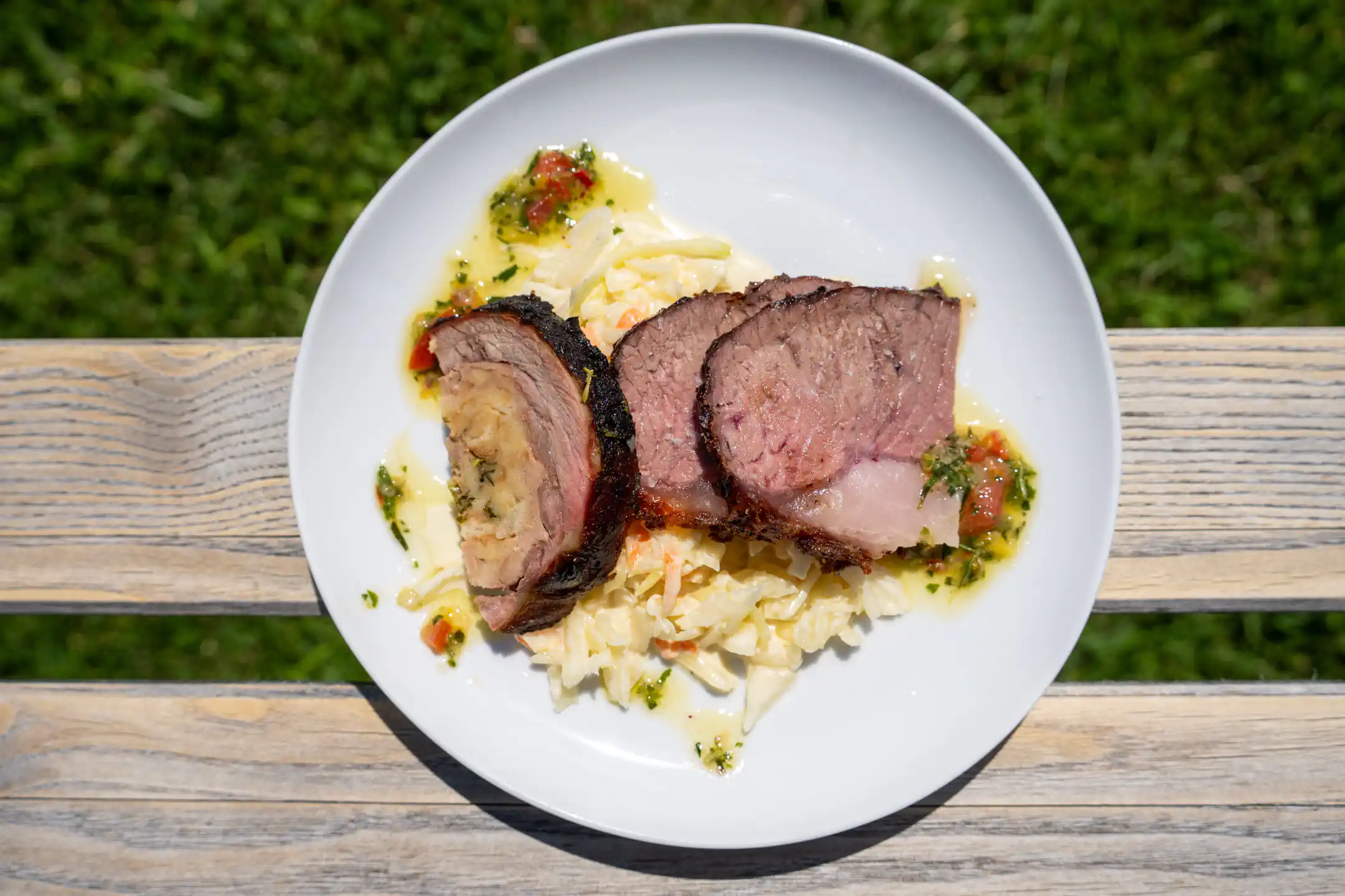 Gegrilltes Fleisch mit Salat und Kräutersauce, im Freien serviert