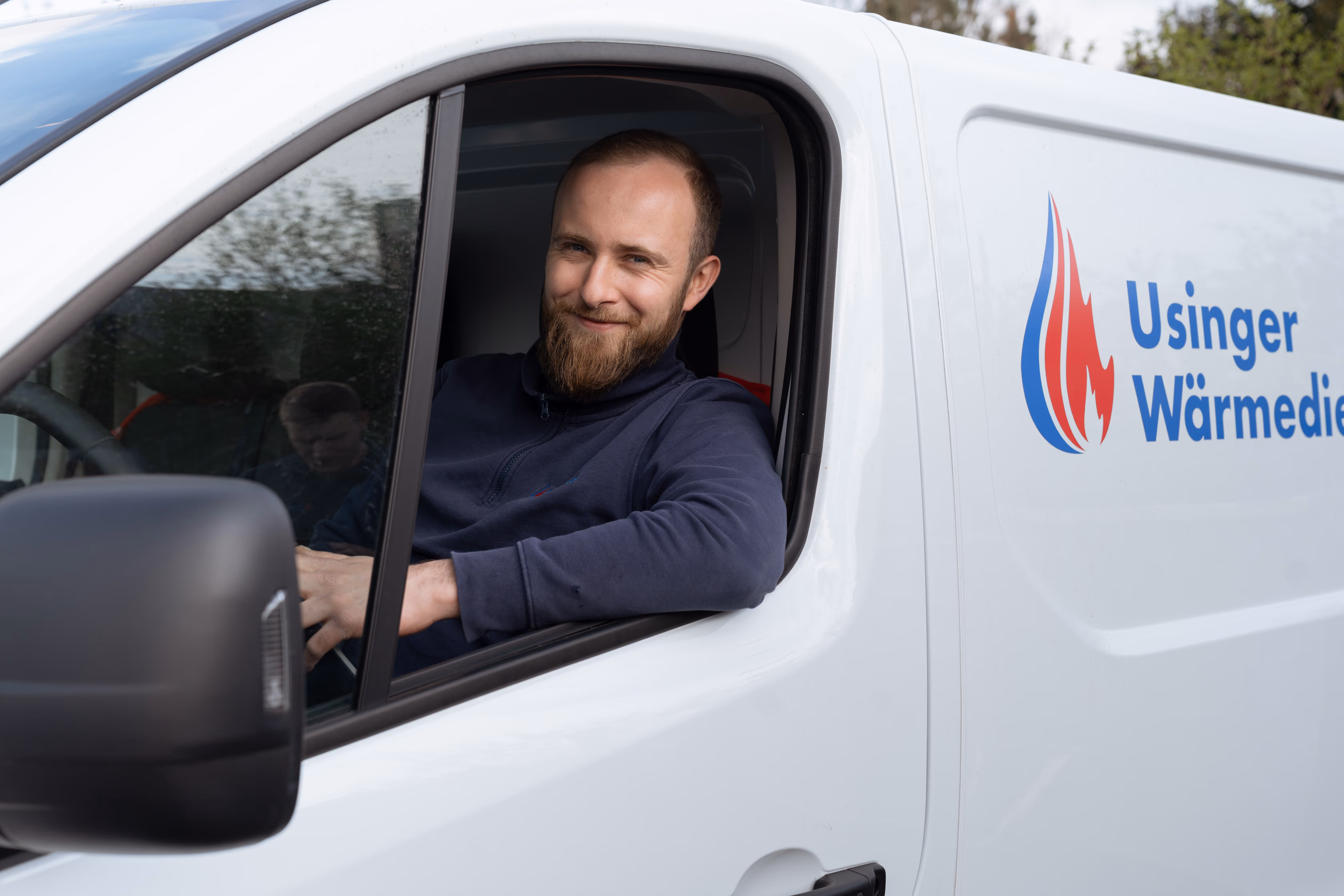 Usinger Wärmedienst Handwerker sitzt im Firmenbus