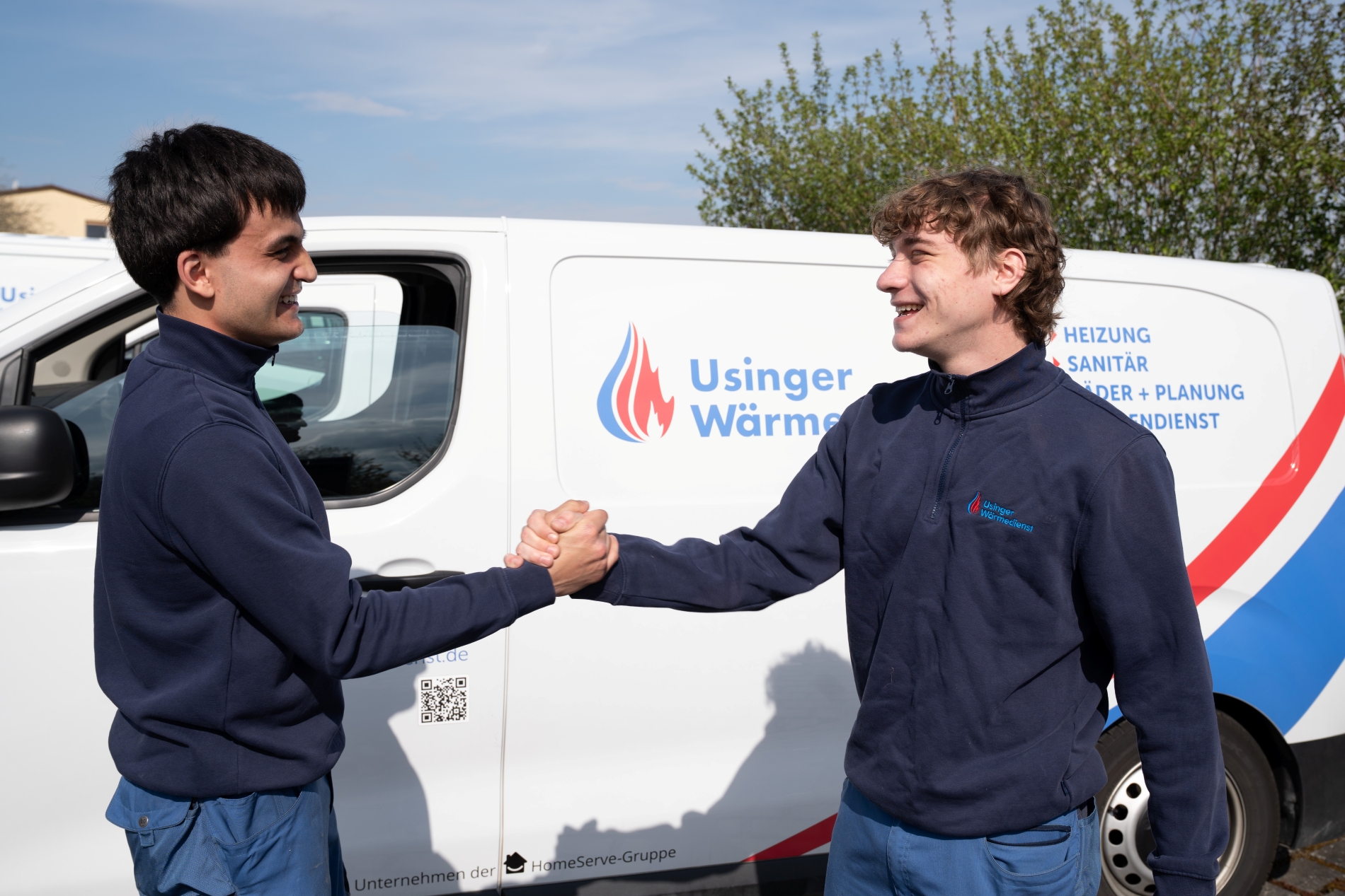 Handshake zweier Usinger Wärmedienst Handwerker vor Firmenwagen