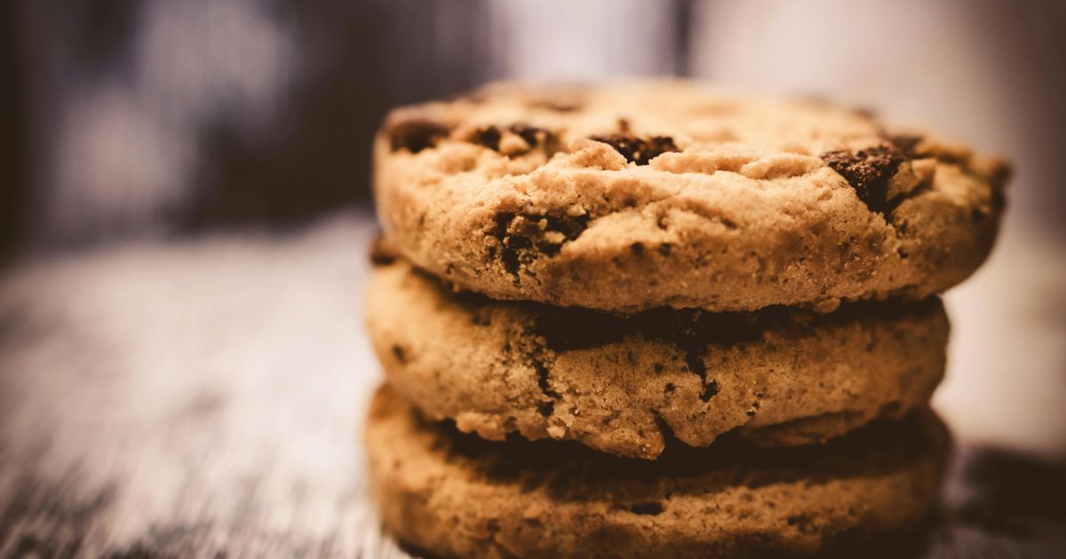 Photo de trois cookies fais maison empilés sur une table en bois