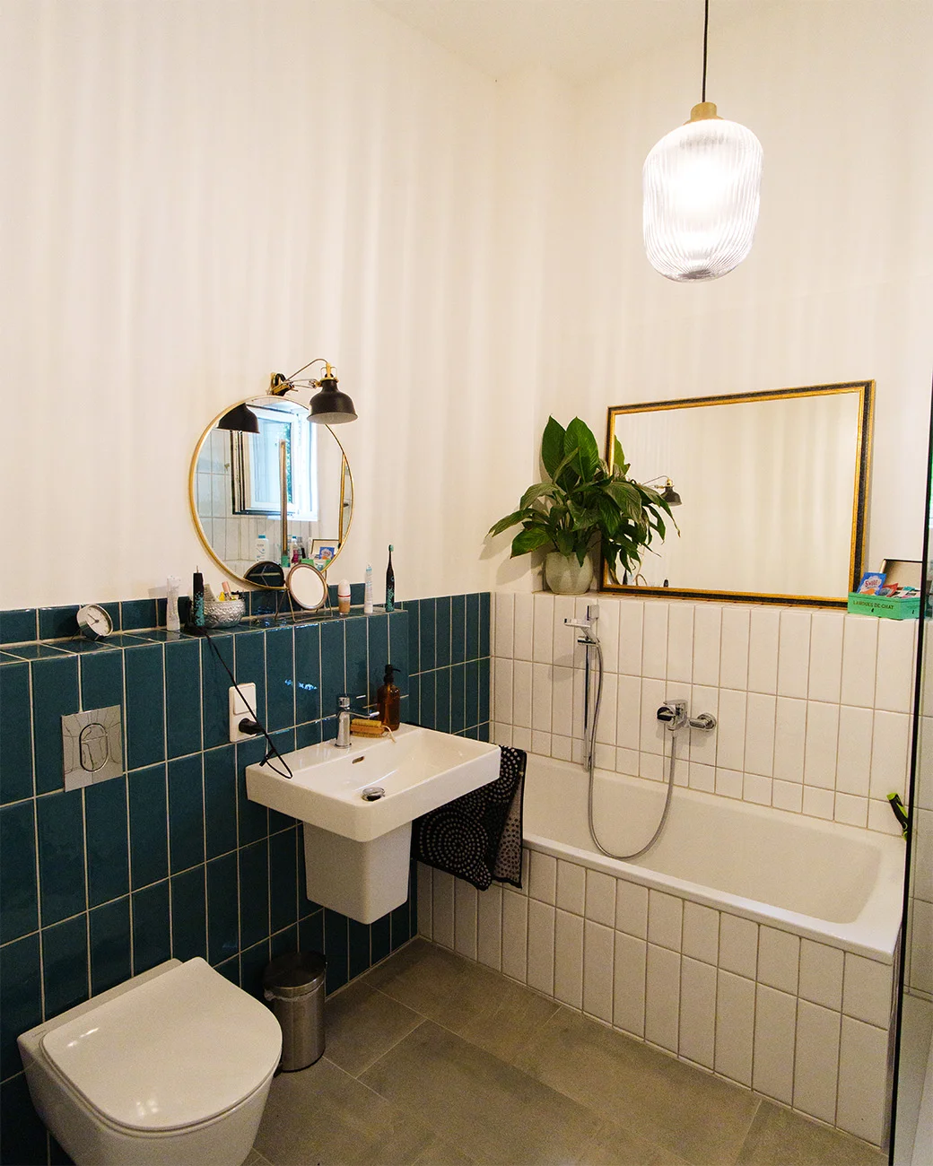 Saniertes Bad von Takatukabau: Wanne, Hänge-WC und Waschbecken mit petrol-weißer Fliesenwand in Freiburg.