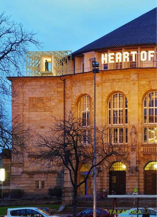 Beleuchteter Holz-Aussichtskubus von Takatukabau auf dem Stadttheater Freiburg – Sonderbau als „Türmerstube“ bei Nacht.