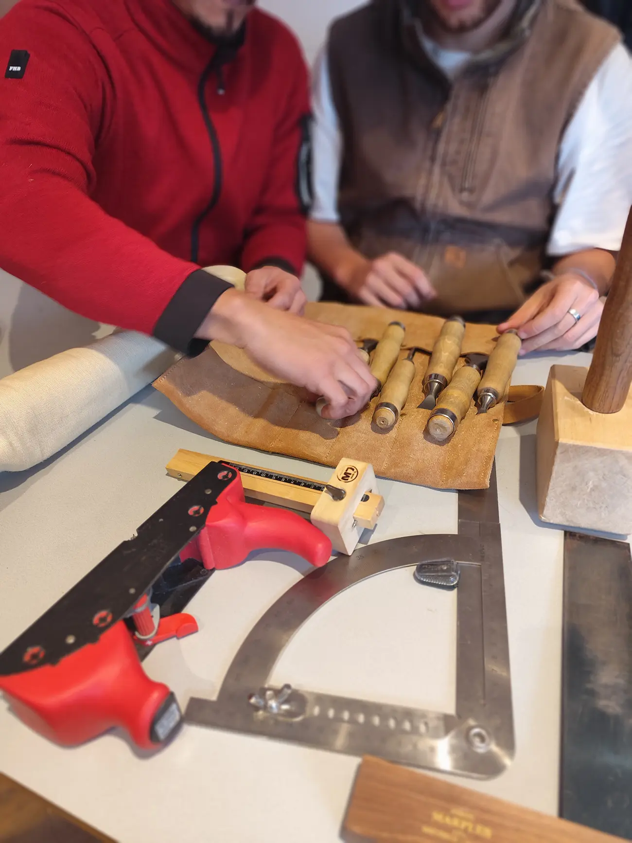 Teilnehmer betrachten japanische Handwerkzeuge bei einem Holzbau-Workshop