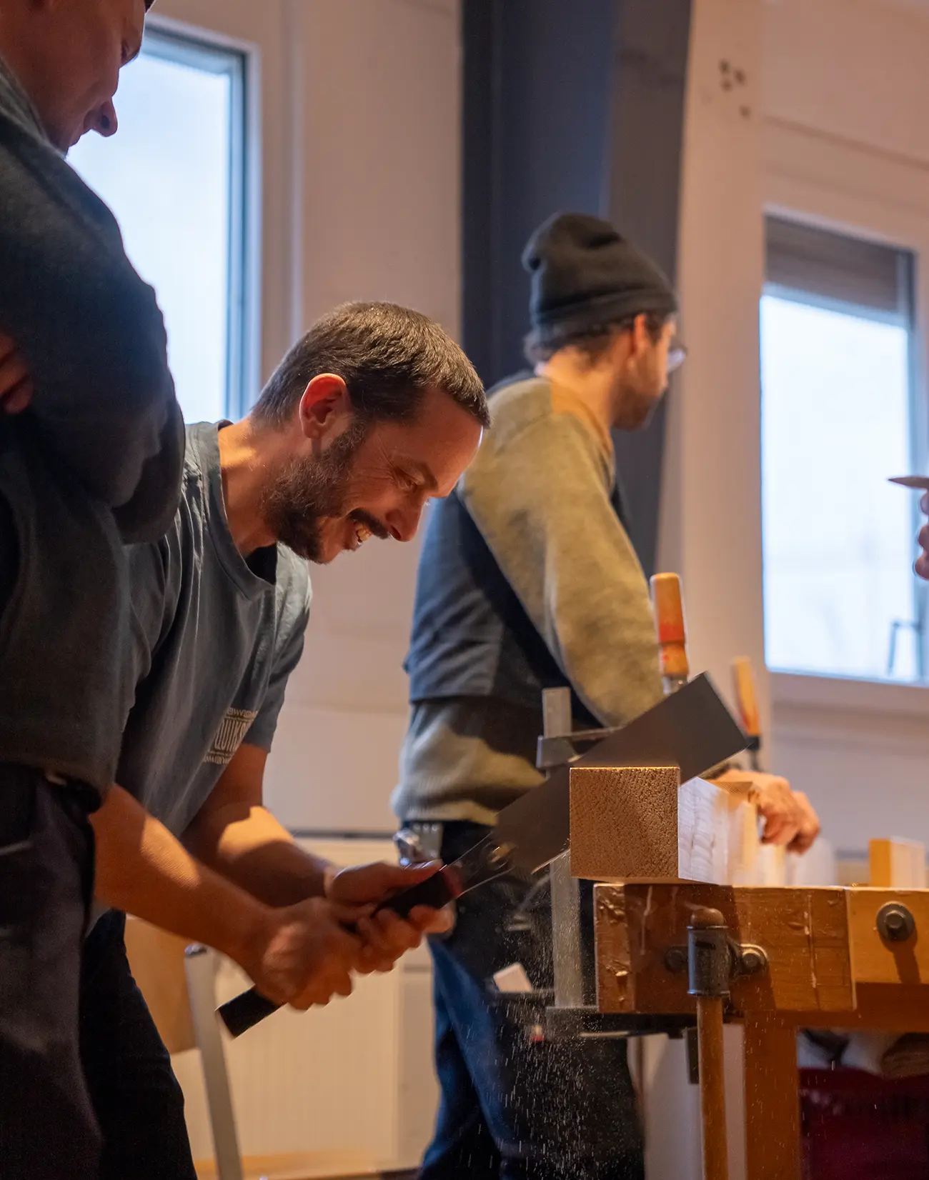 Teilnehmer bearbeitet ein Holzstück an der Werkbank