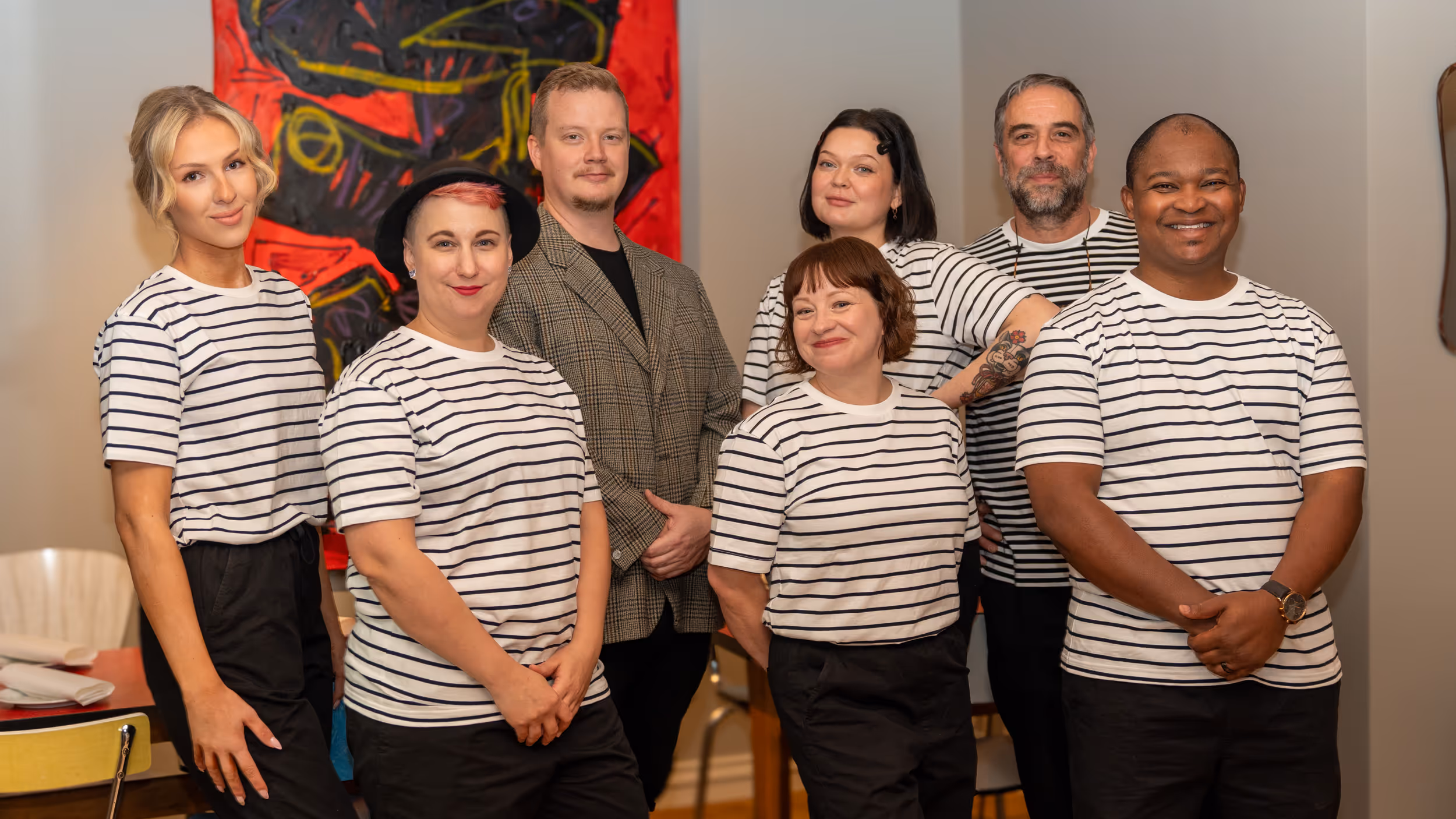 Restaurant Madame team posing together, with staff in striped shirts and our manager in a blazer.