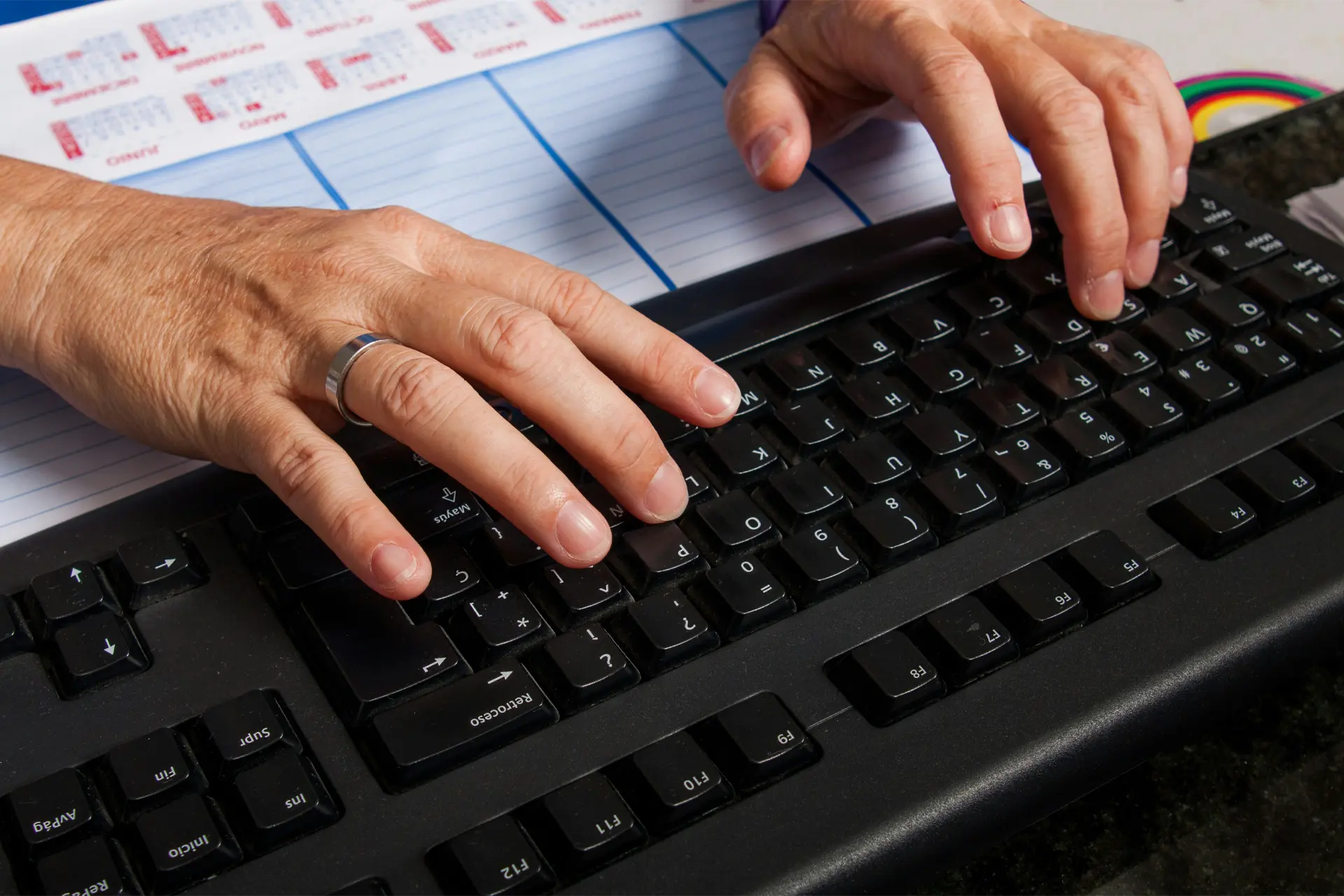 Hands typing on laptop keyboard