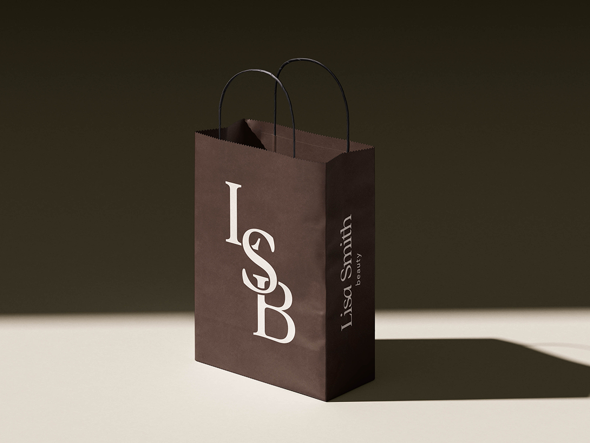 A dark brown bag with Lisa Smith Beauty's logos in cream against a tan background.