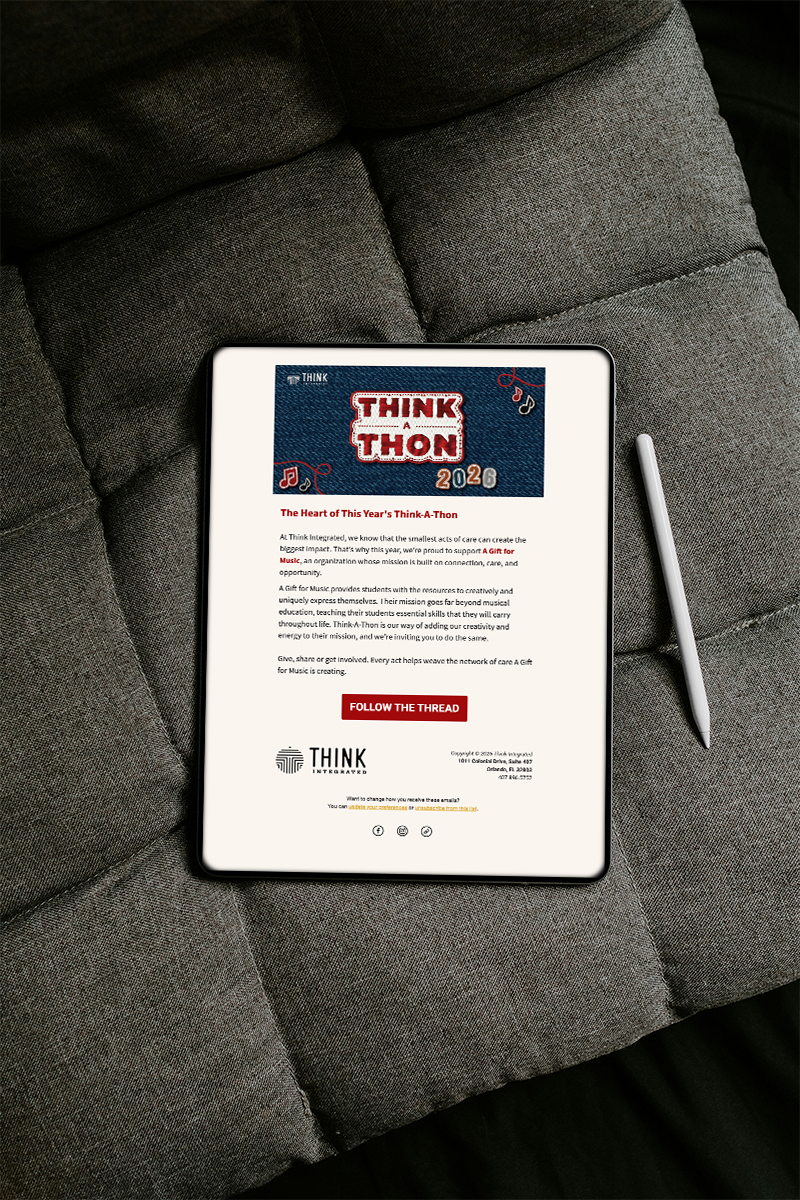 An iPad on a gray couch with an email design for Think-A-Thon.