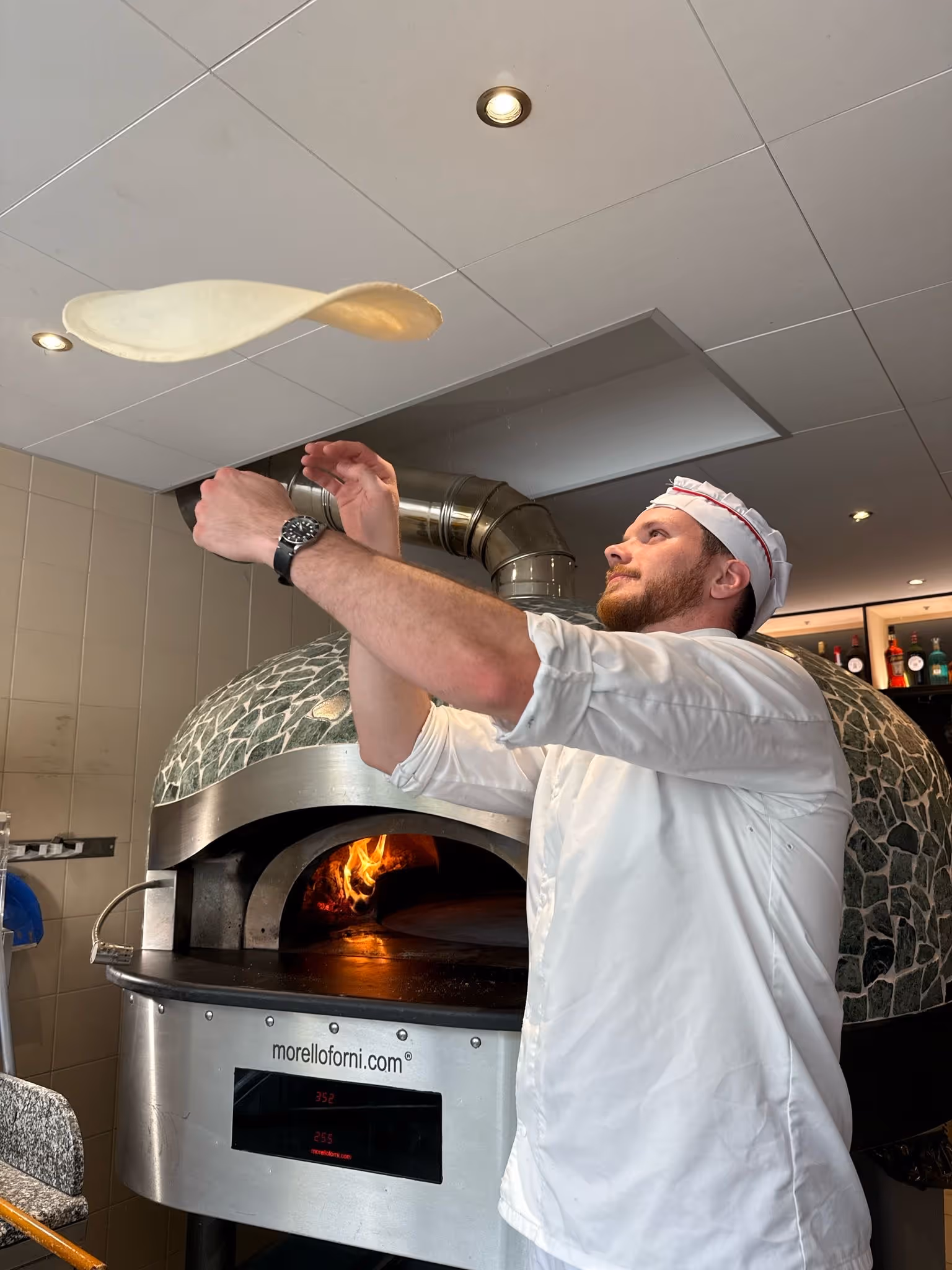 Pizzaiolo qui fait tourner une pate a pizza