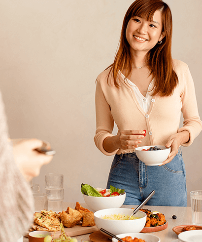 A woman smiling at a colleague, eating lunch