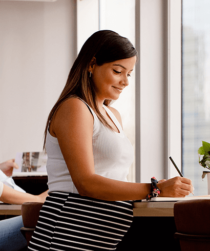 A pregnant woman working in a notebook