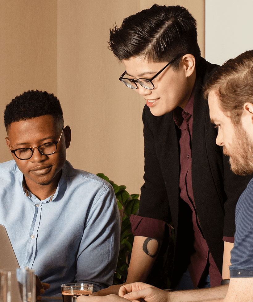 Three people collaborating on a laptop