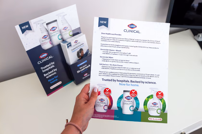 person holding a Clorox Clinical product information sheet