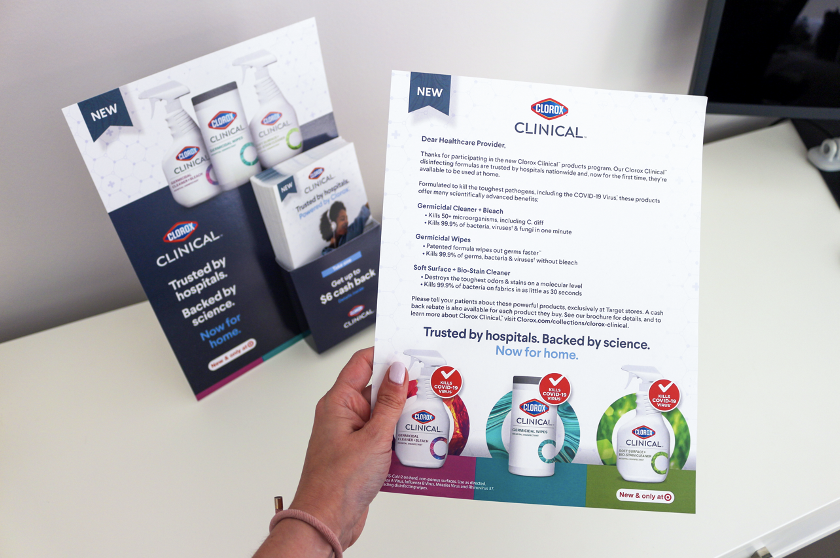 person holding a Clorox Clinical product information sheet