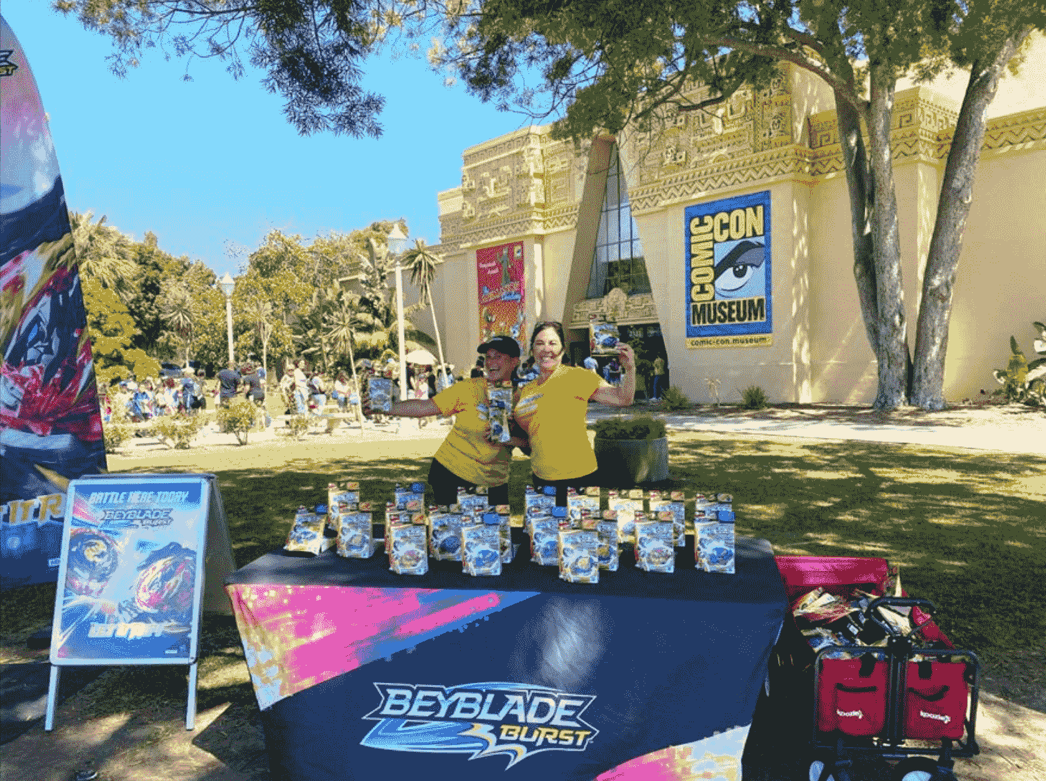 two woman holding  beyblade burst samples