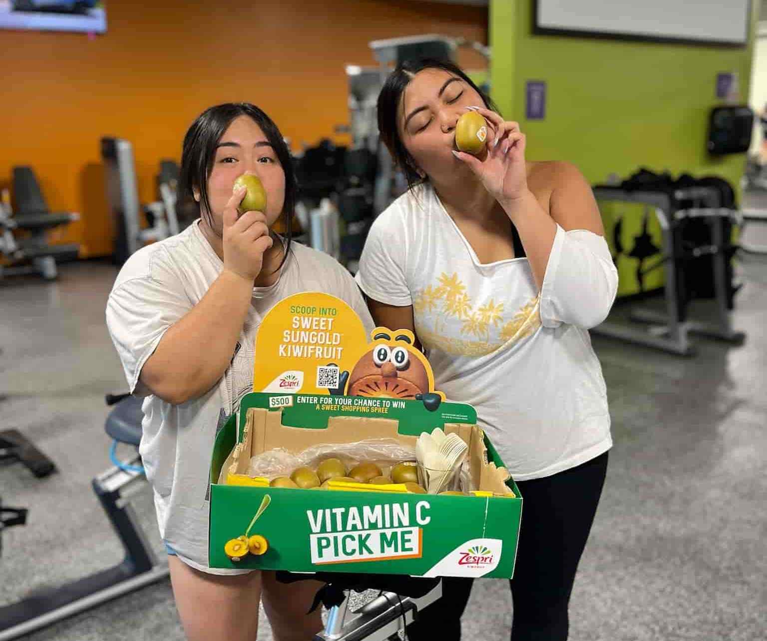two women posing with kiwi samples