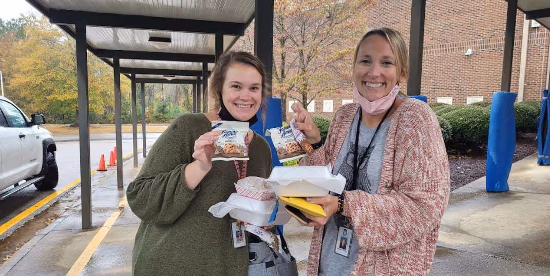 two woman holding famous amos samples