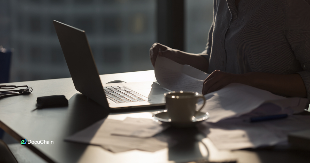 Woman prepares printed documents for approval, underlining delays that DocuChain solves with online signature tools