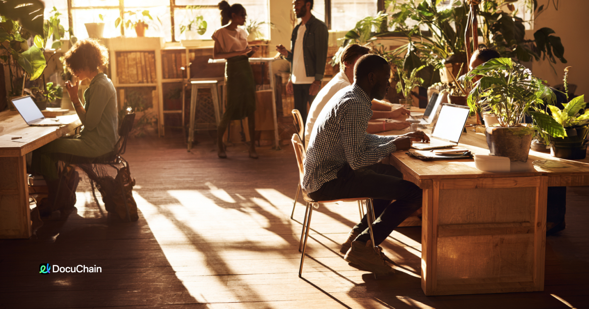 Team members in coworking space struggle with document signing delays, showing the cost of outdated workflows in deal closure