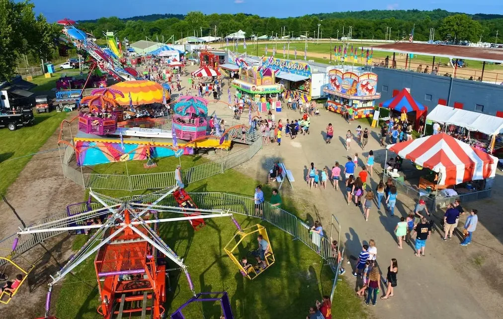 An aerial view of a carnival with a ferris wheel.