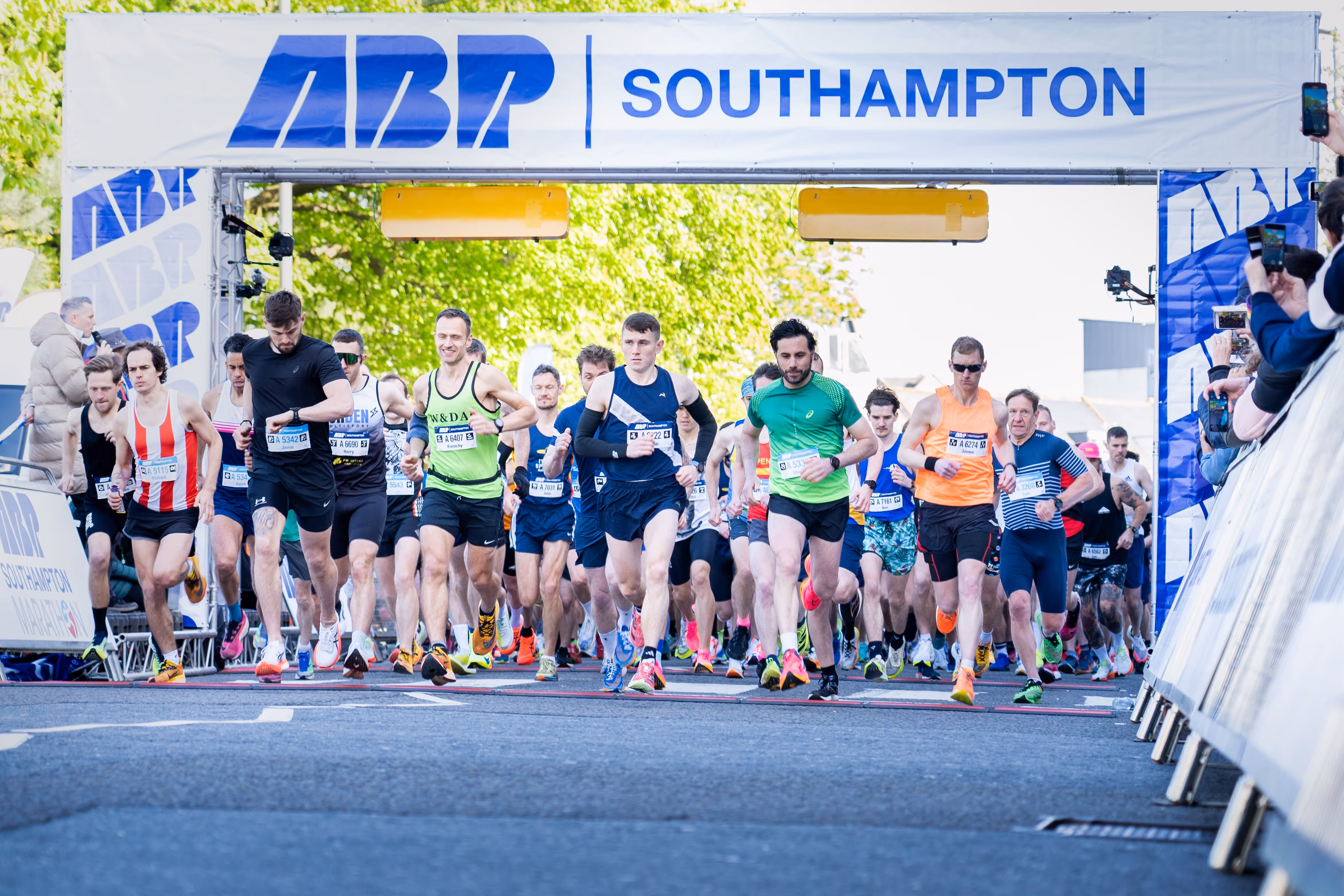 Runners at the start line at the ABP Southampton Marathon 2024 with cheering crowds.